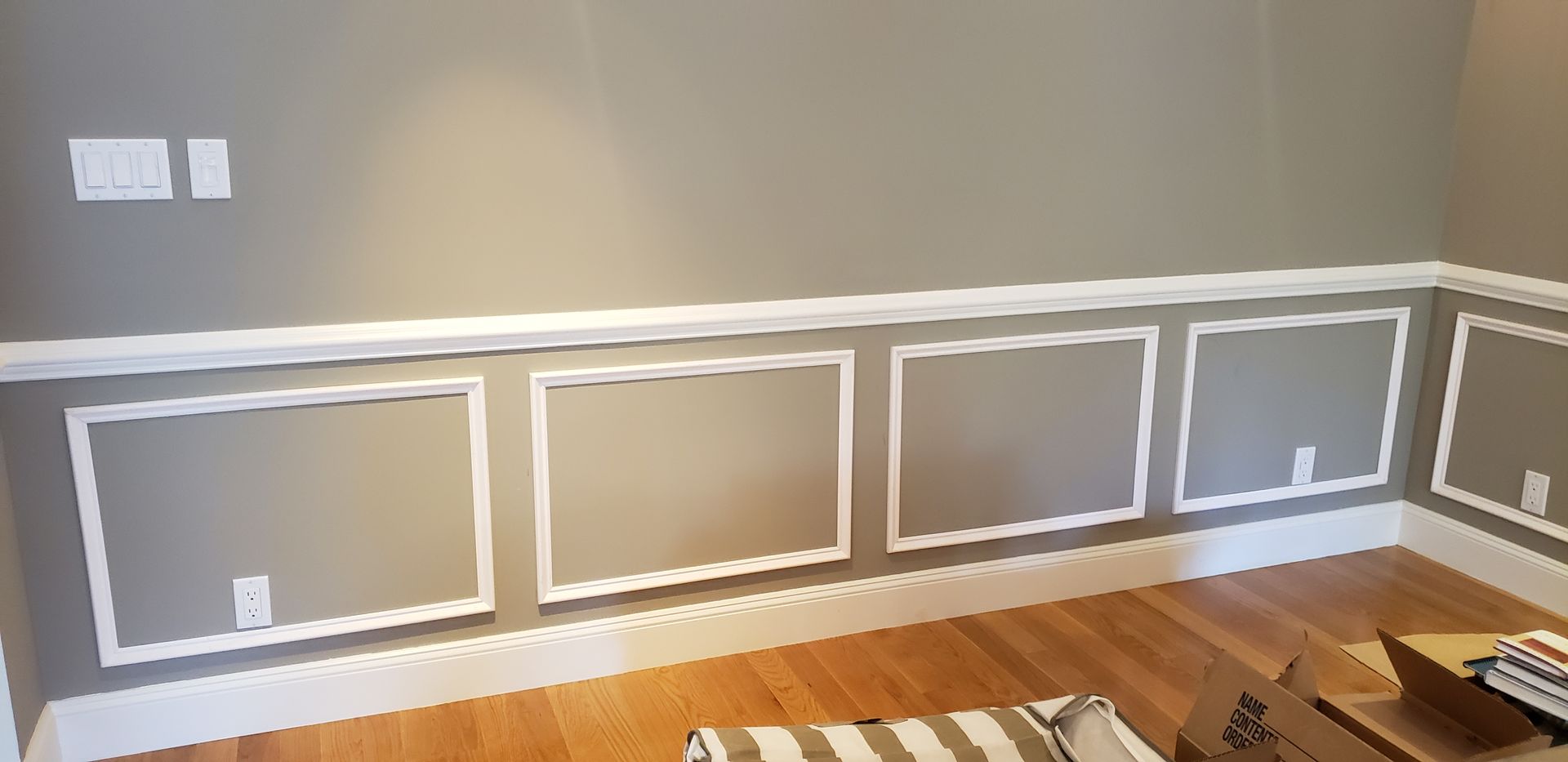 A hand using a power drill to install a door lock on a white door.