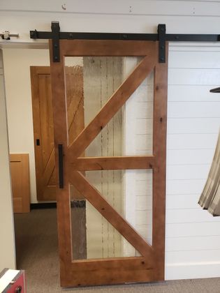 A person in overalls installs a brown door in a white room.