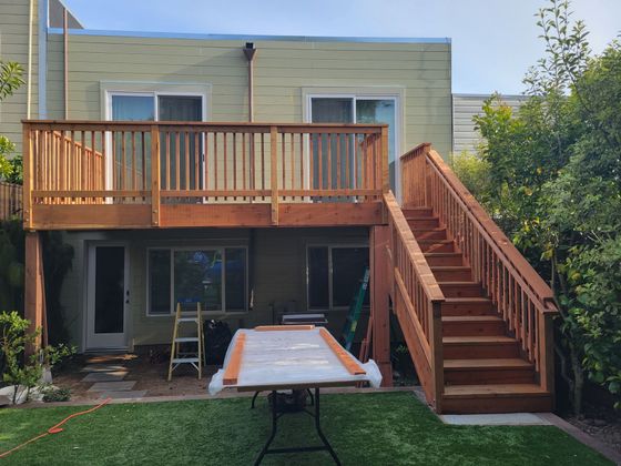 A person in overalls installs a brown door in a white room.