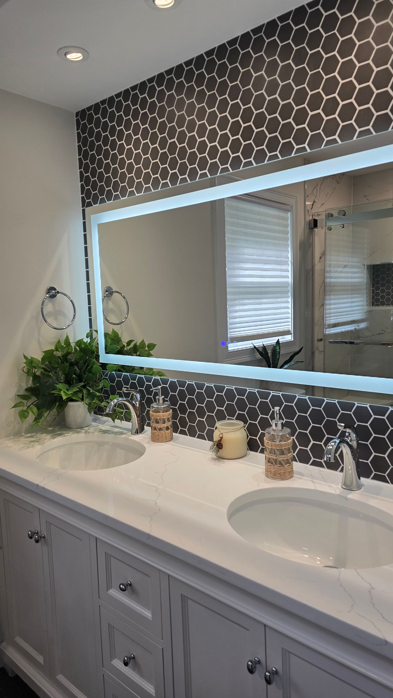 A bathroom with two sinks and a large mirror.