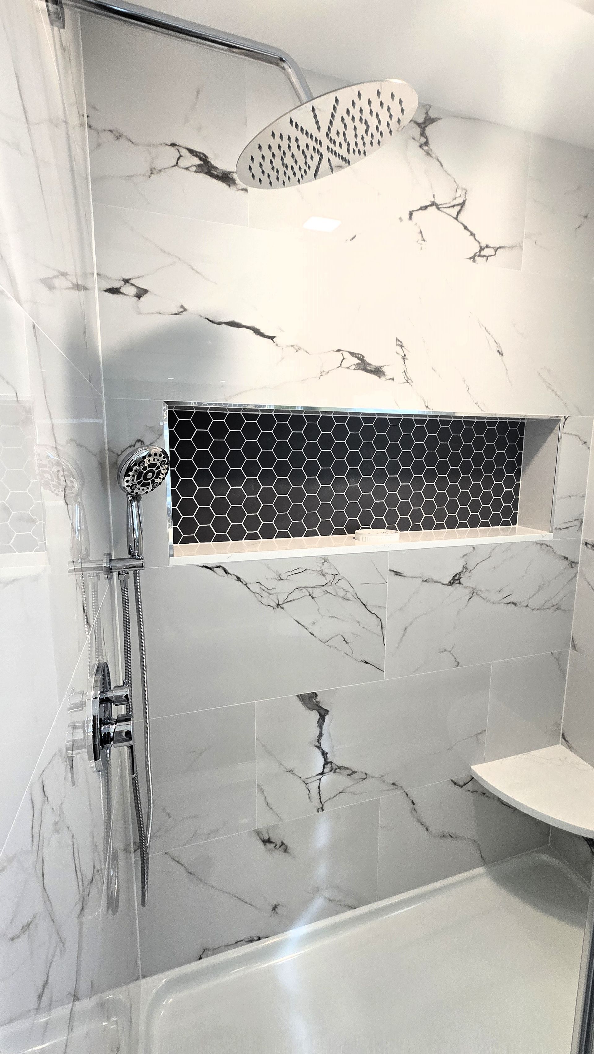 A bathroom with a shower head and a shelf.