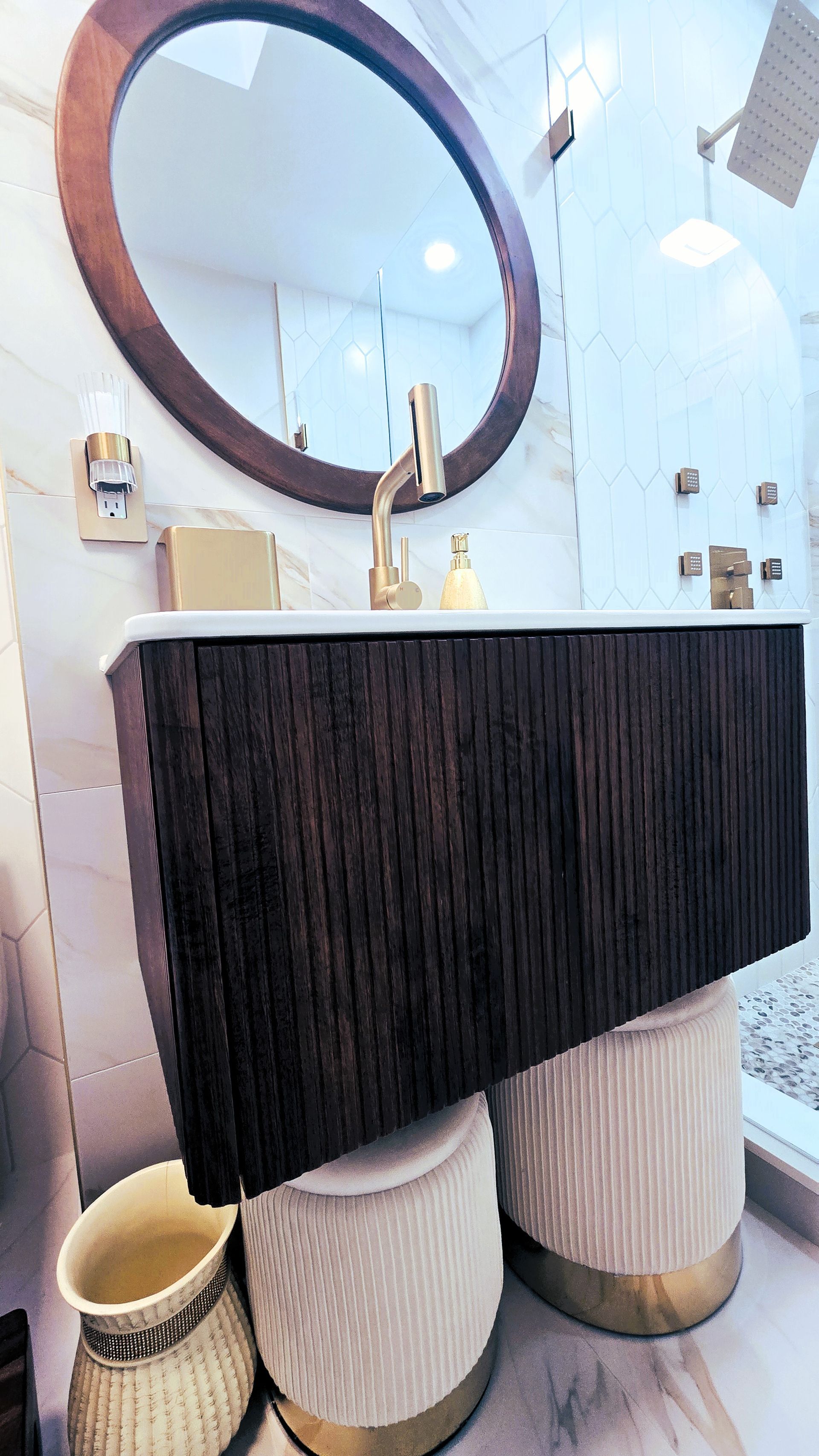 A bathroom with a sink , mirror , and vases.