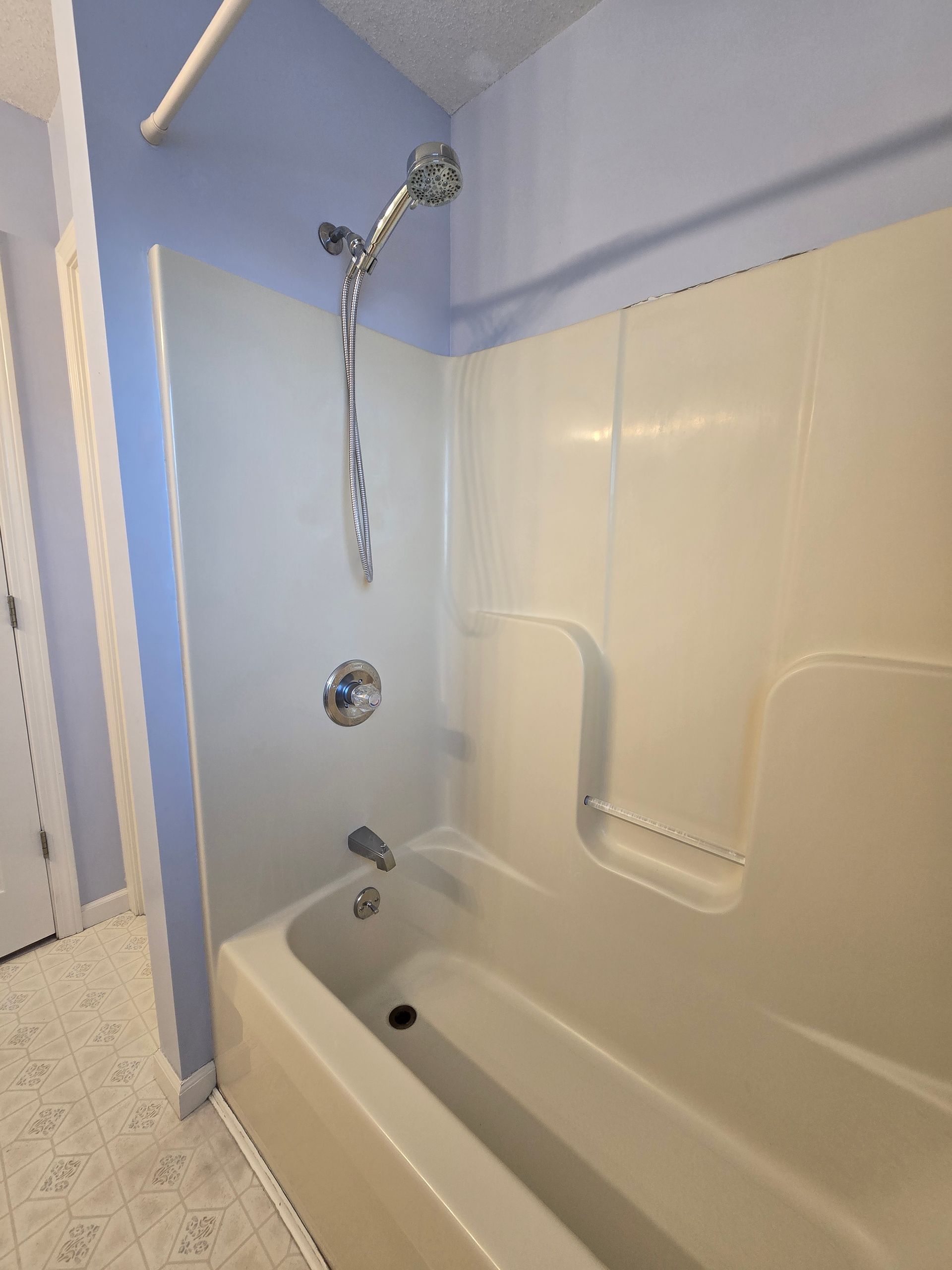 A bathroom with a bathtub and a shower head