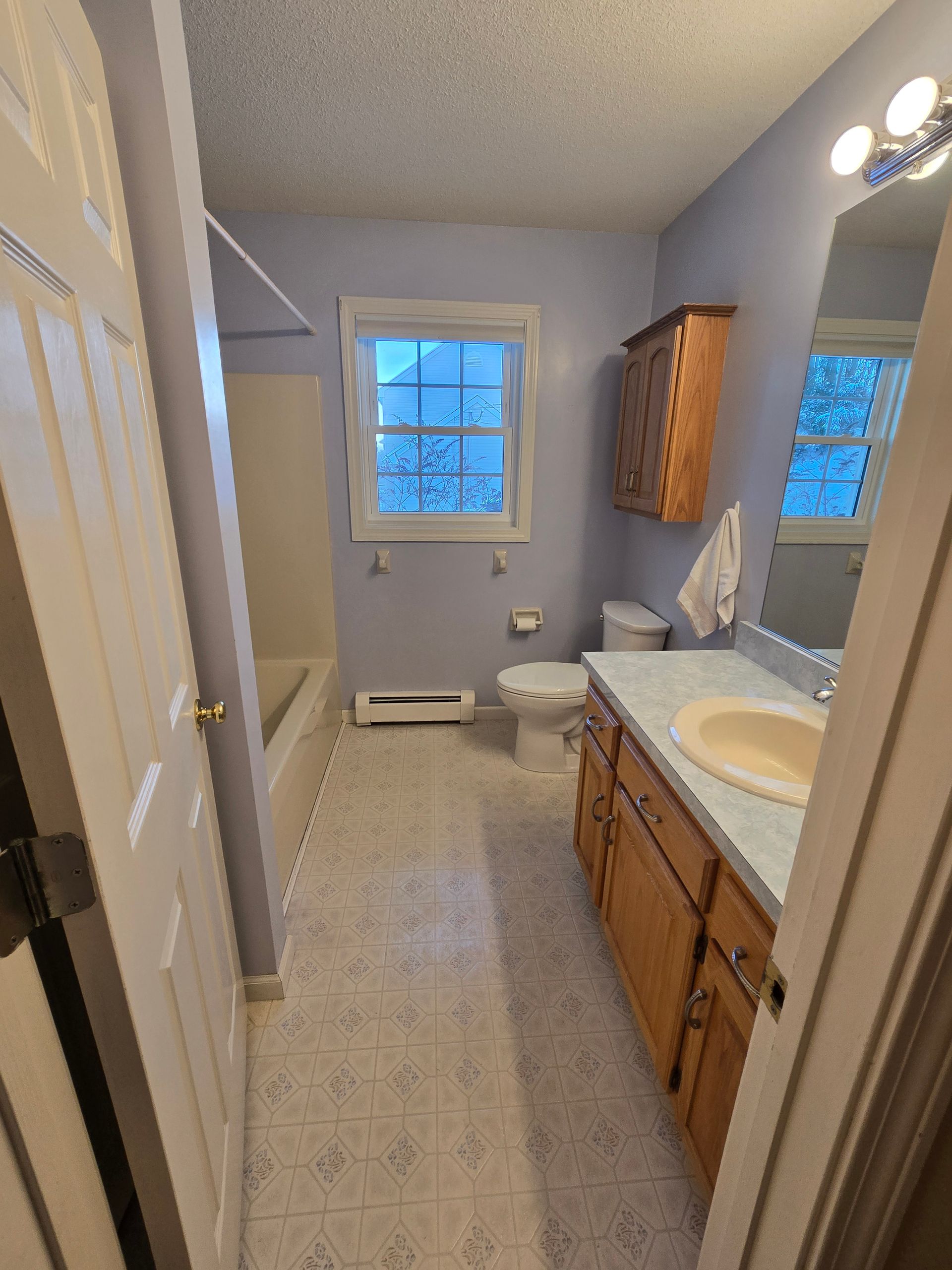 A bathroom with a sink a toilet and a window