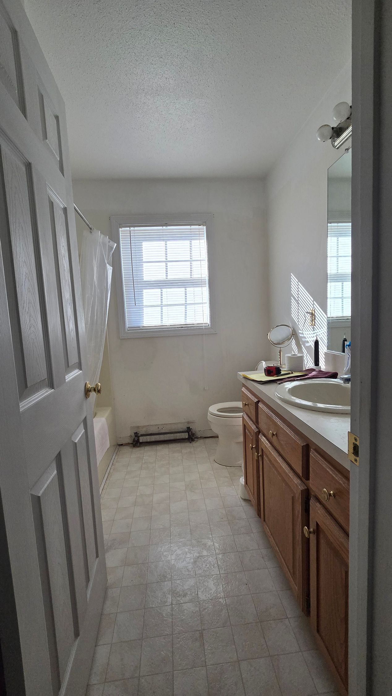 A bathroom with a walk in shower with a wooden wall and marble tiles.