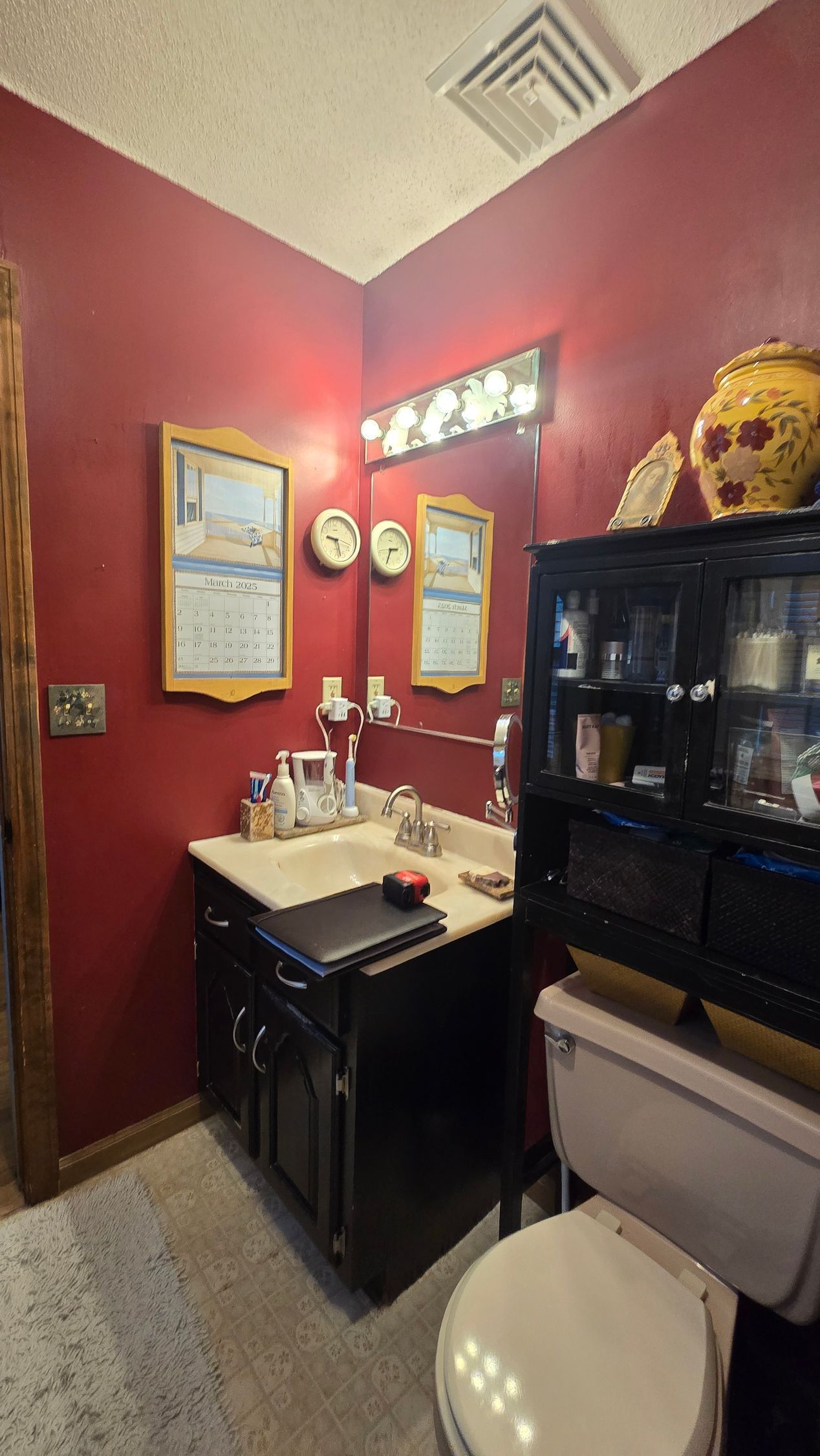 A bathroom with red walls , a sink and a toilet.