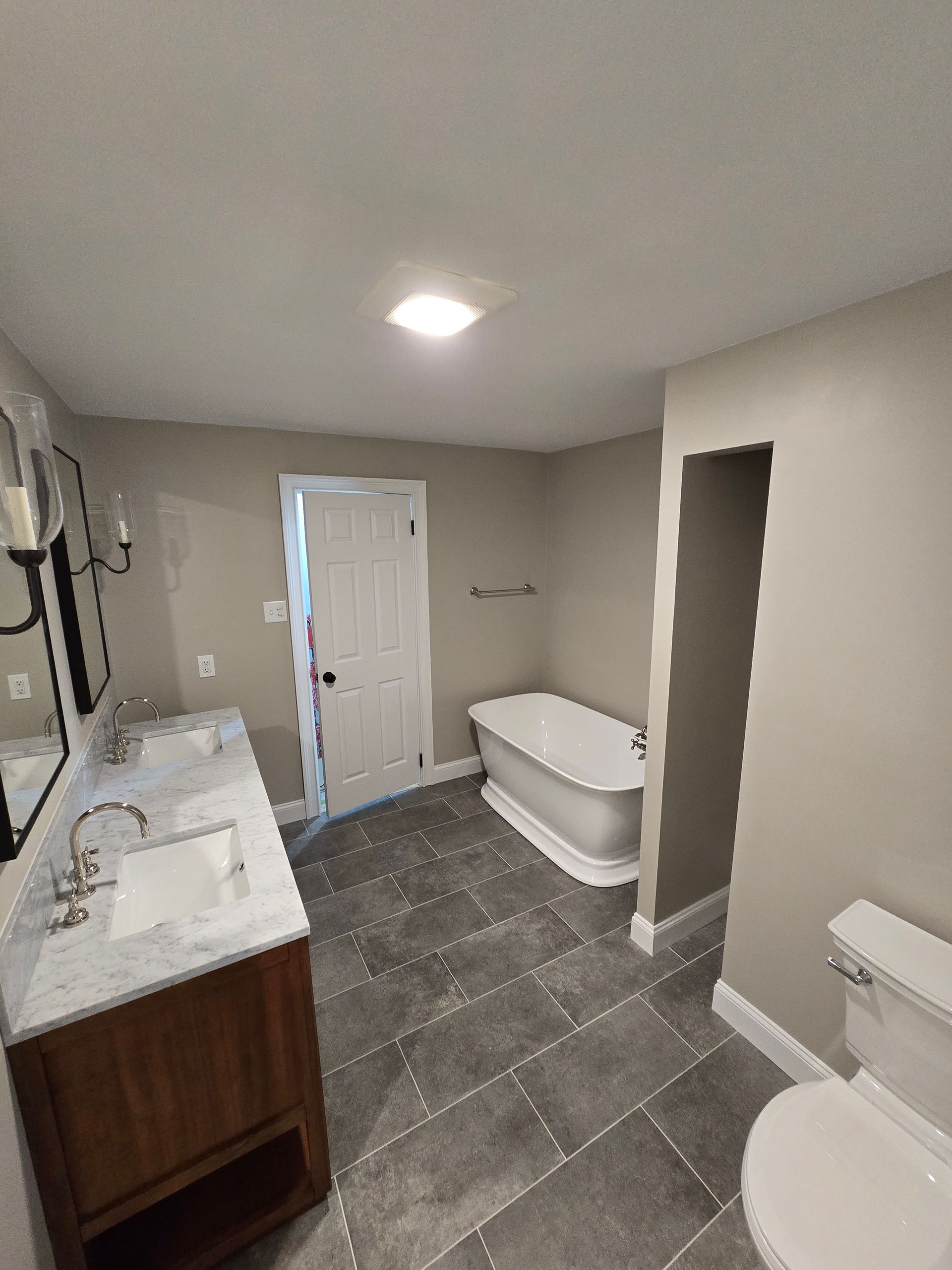 A bathroom with a bathtub a toilet a sink and a mirror