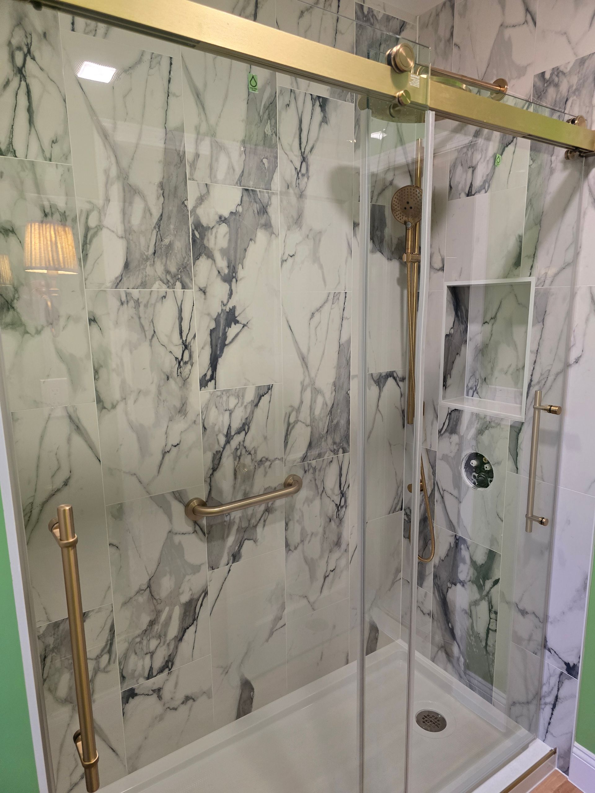 A bathroom with a walk in shower and a shower head