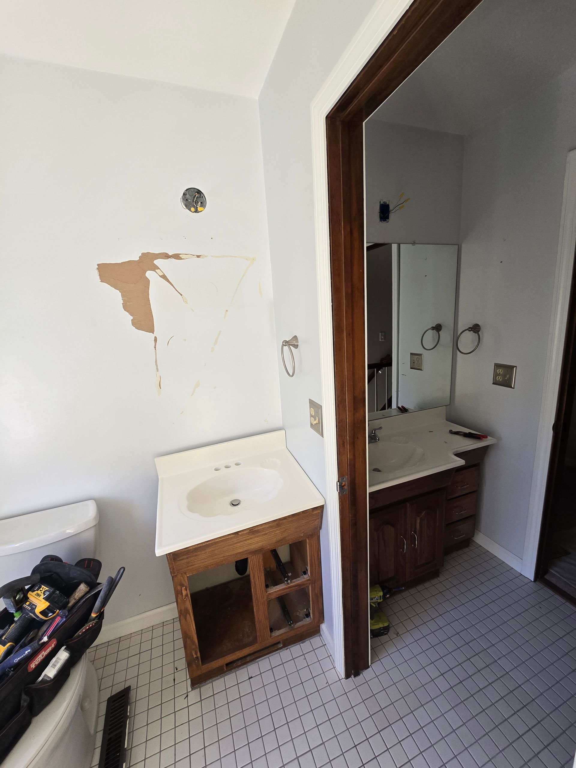 A bathroom with a shower , sink , and door.