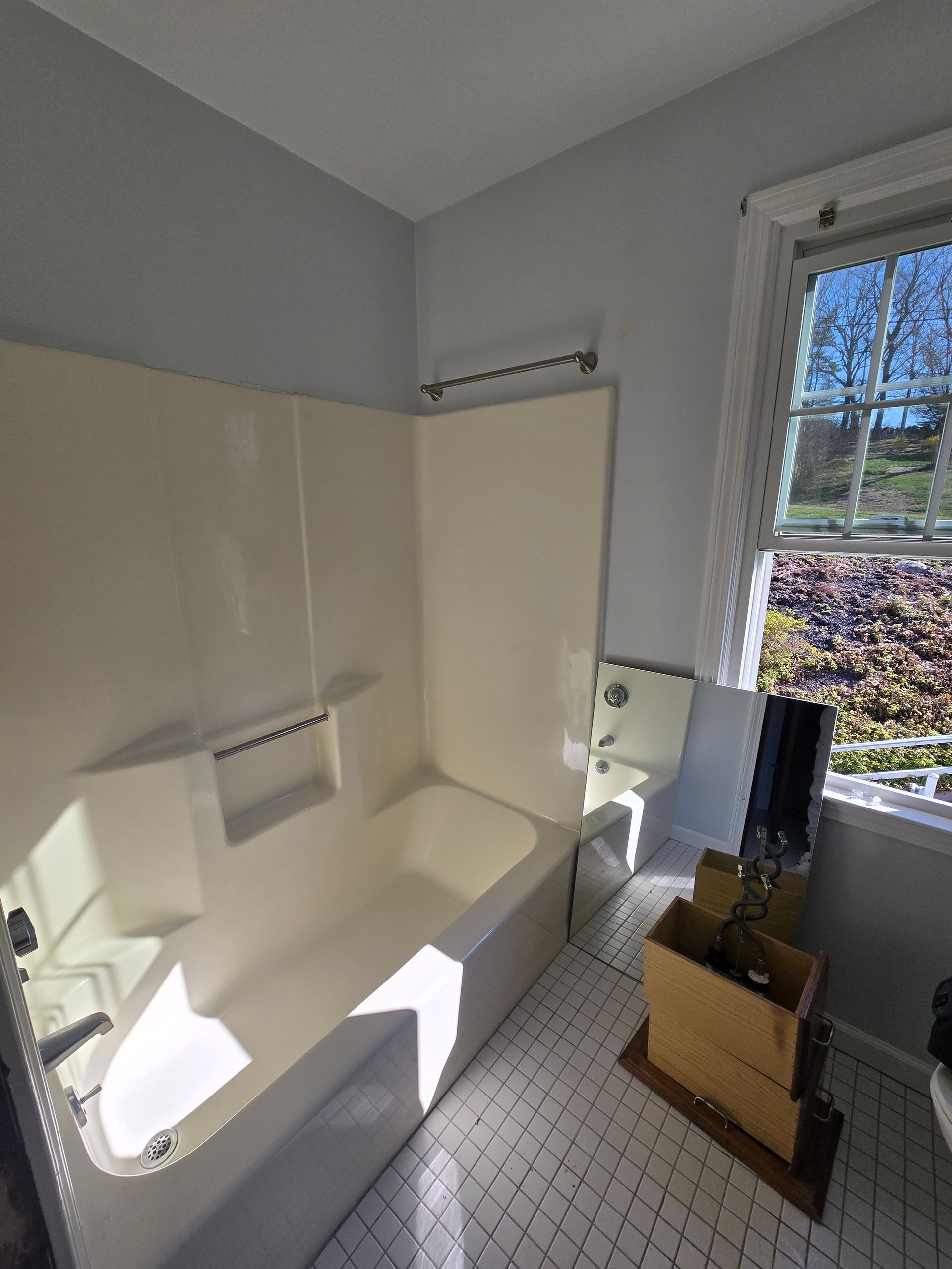 A bathroom with a shower , sink , and door.