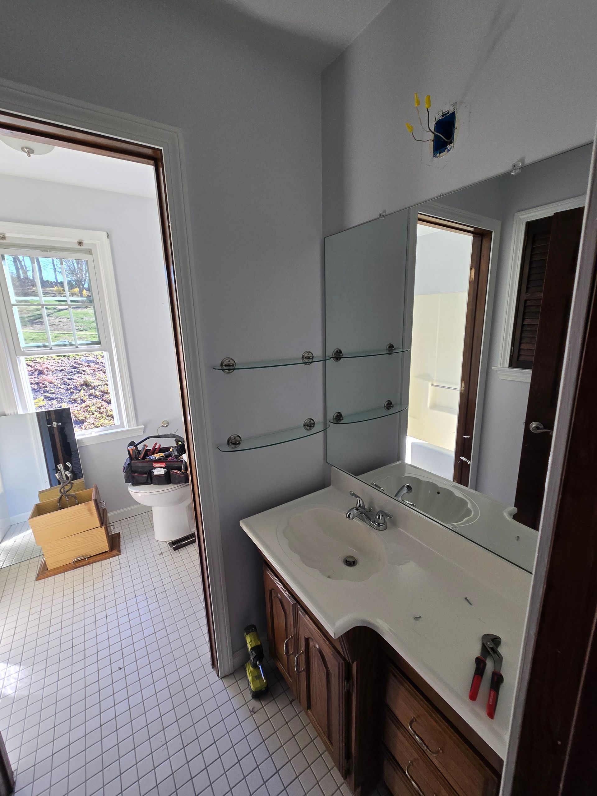 A bathroom with a sink , mirror and toilet.