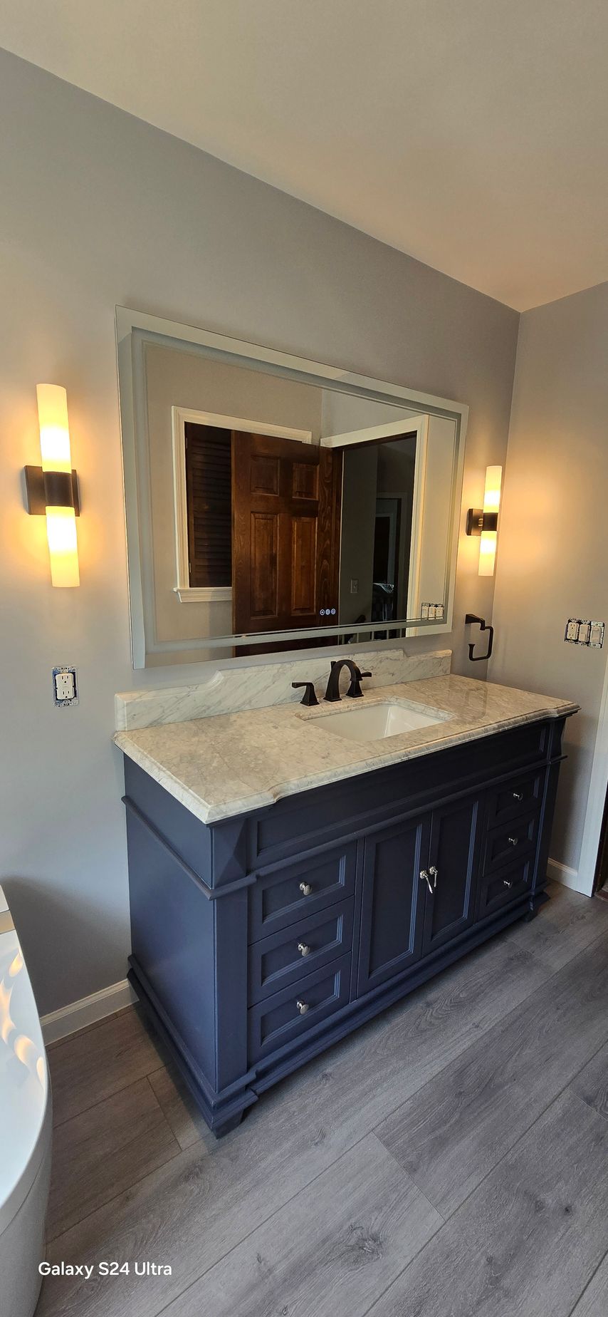 A bathroom with a bathtub and a window.