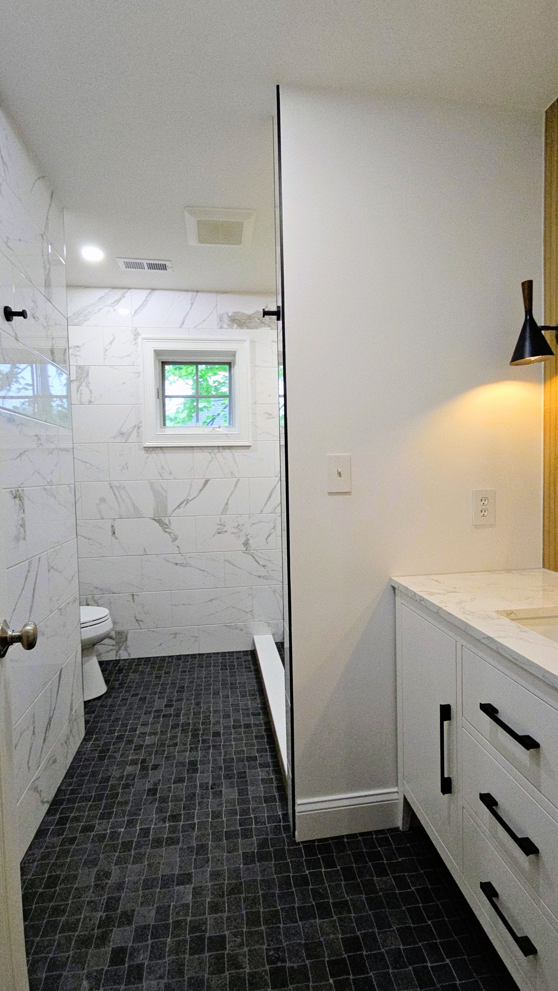 A bathroom with a walk in shower and a sink.