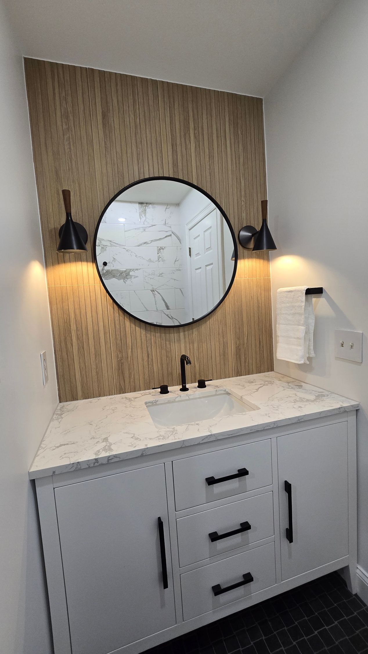 A bathroom with a sink , mirror and cabinets.
