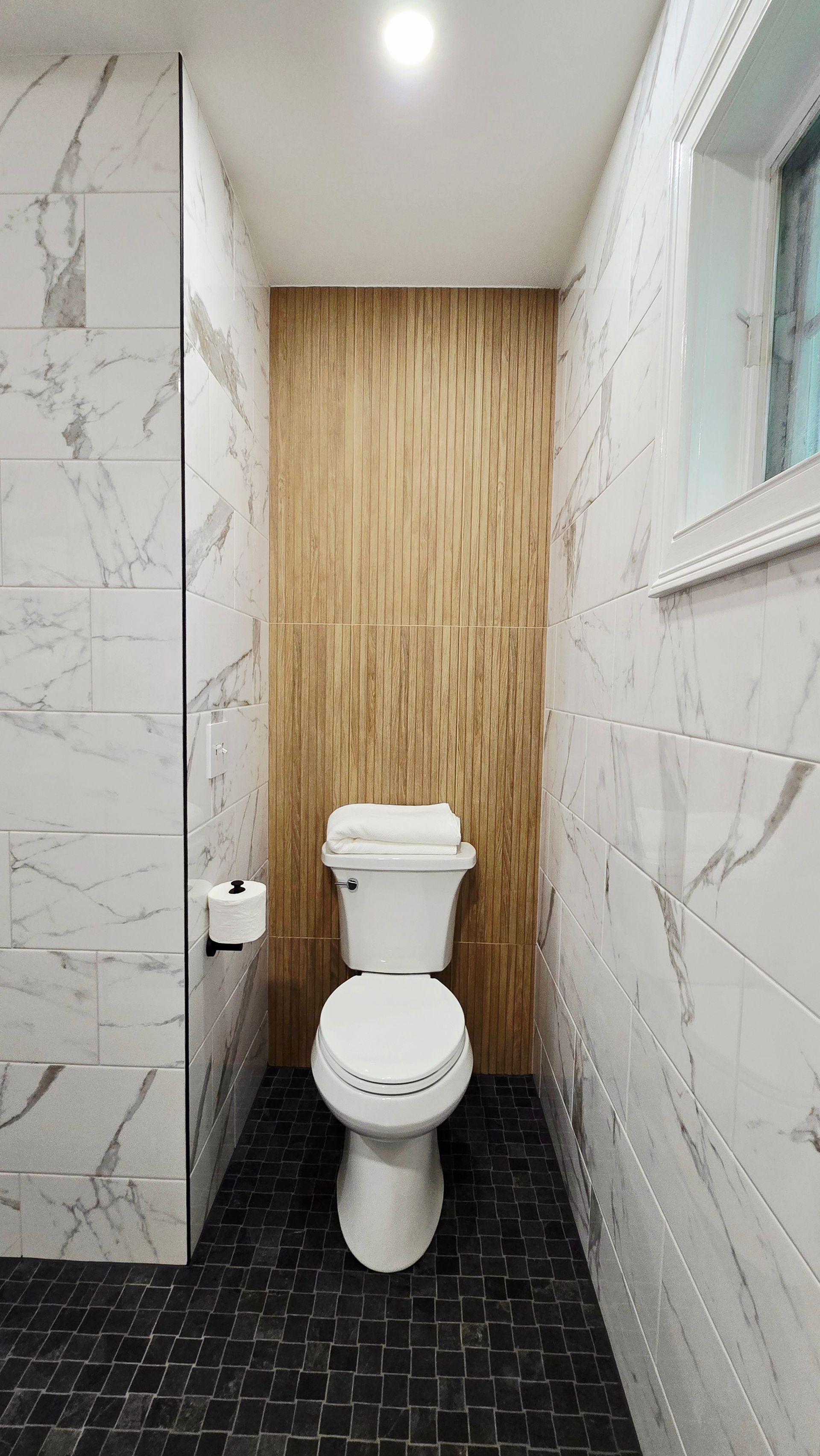 A shower with a bench and a shower head