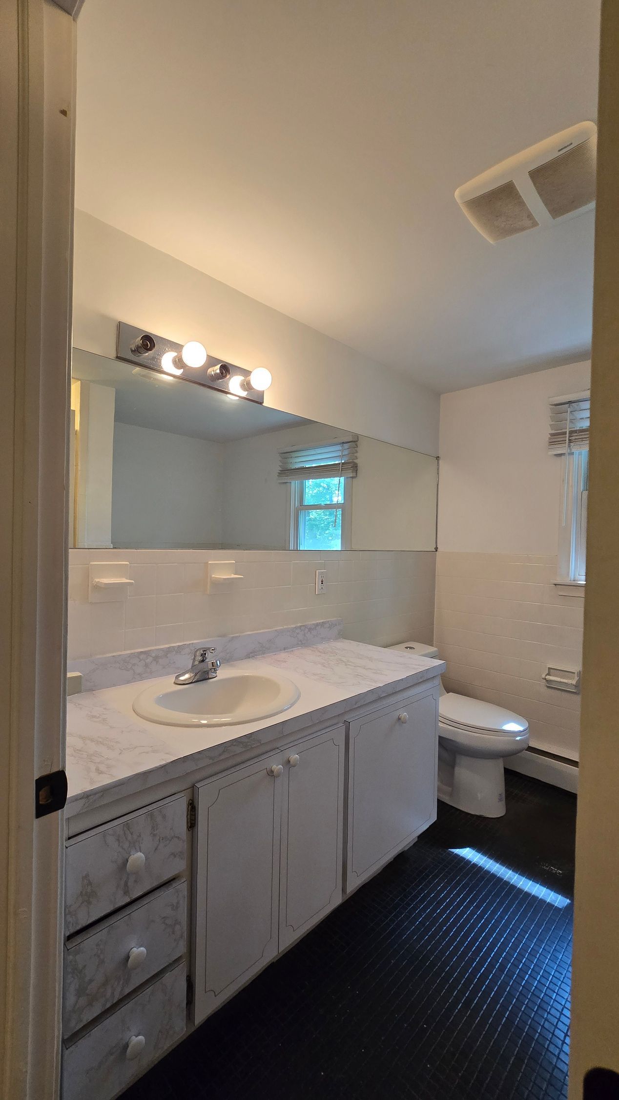 A bathroom with a walk in shower and a sink