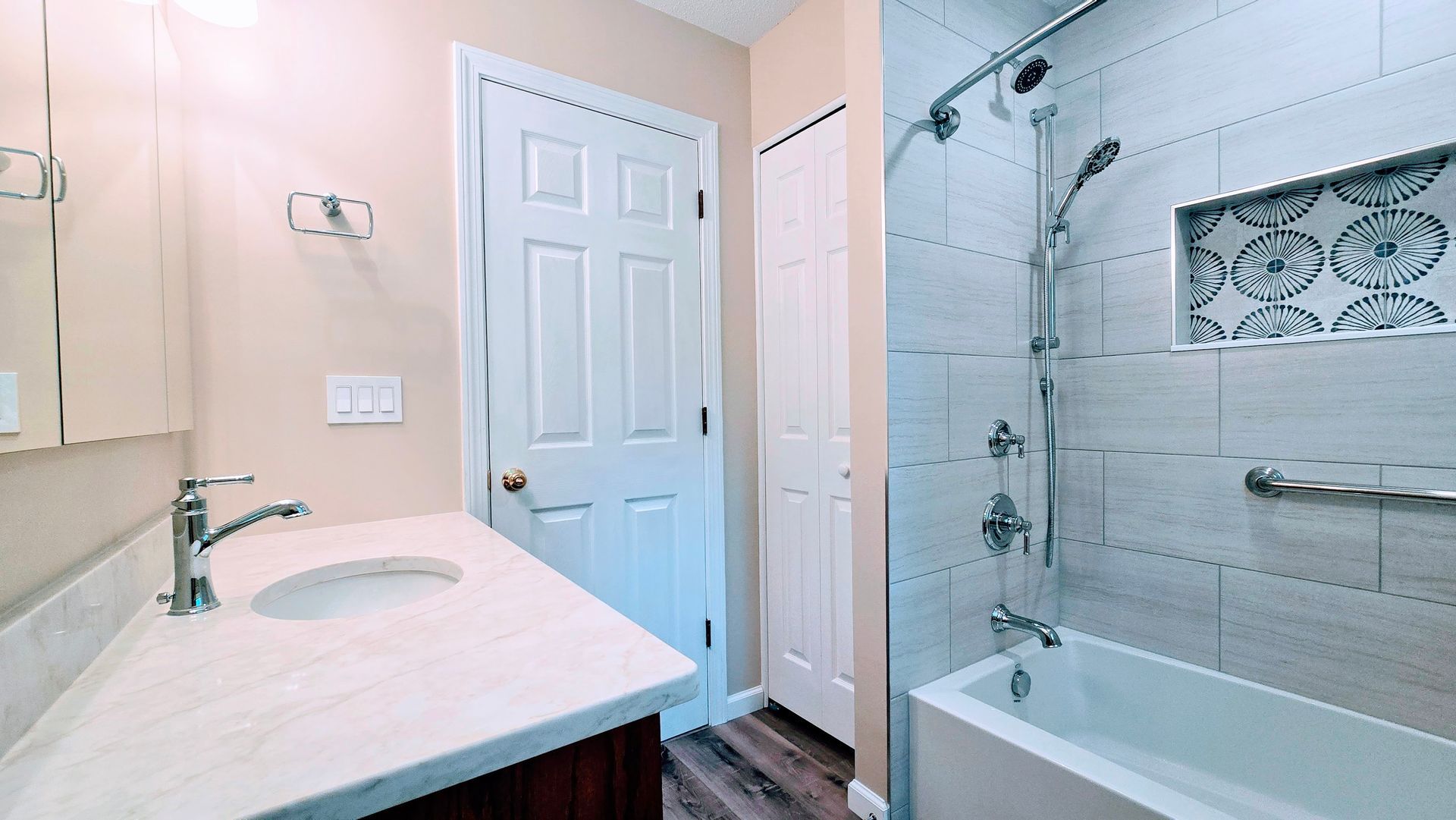 A bathroom with a bathtub , shower , and wooden floor.
