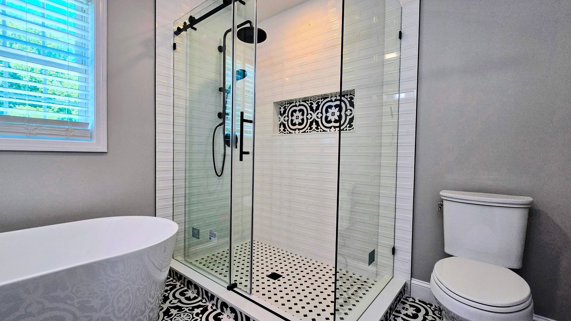 A bathroom with a walk in shower , toilet , tub and window.