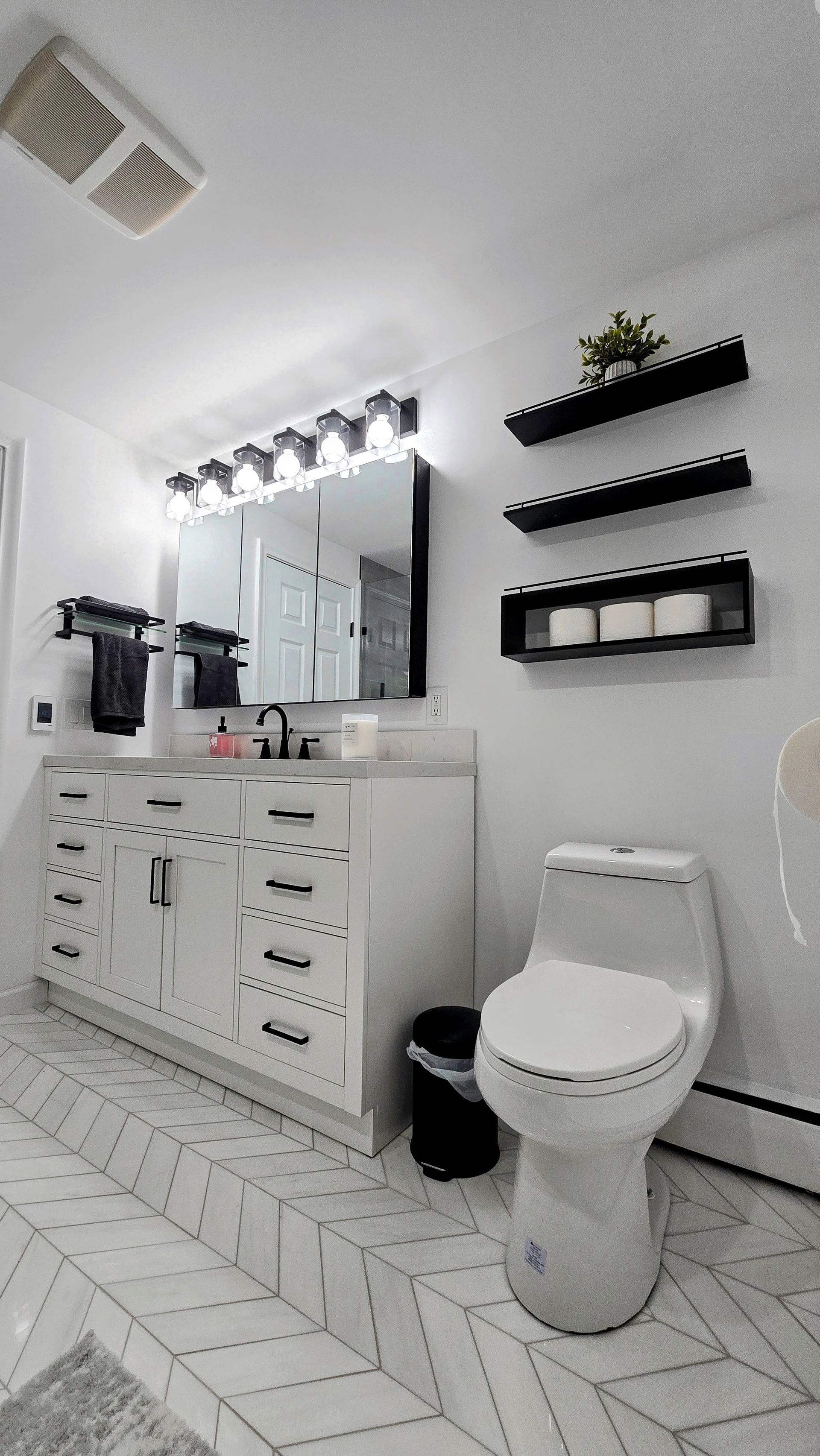 A bathroom with a walk in shower with a wooden wall and marble tiles.