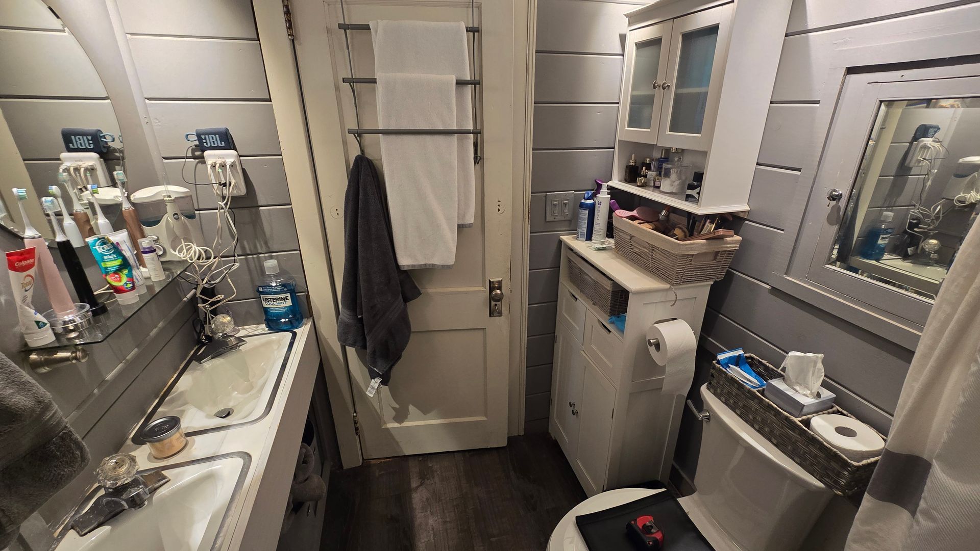Small West Hartford bathroom with a sink, toilet, and cabinet. Gray walls and dark floor.