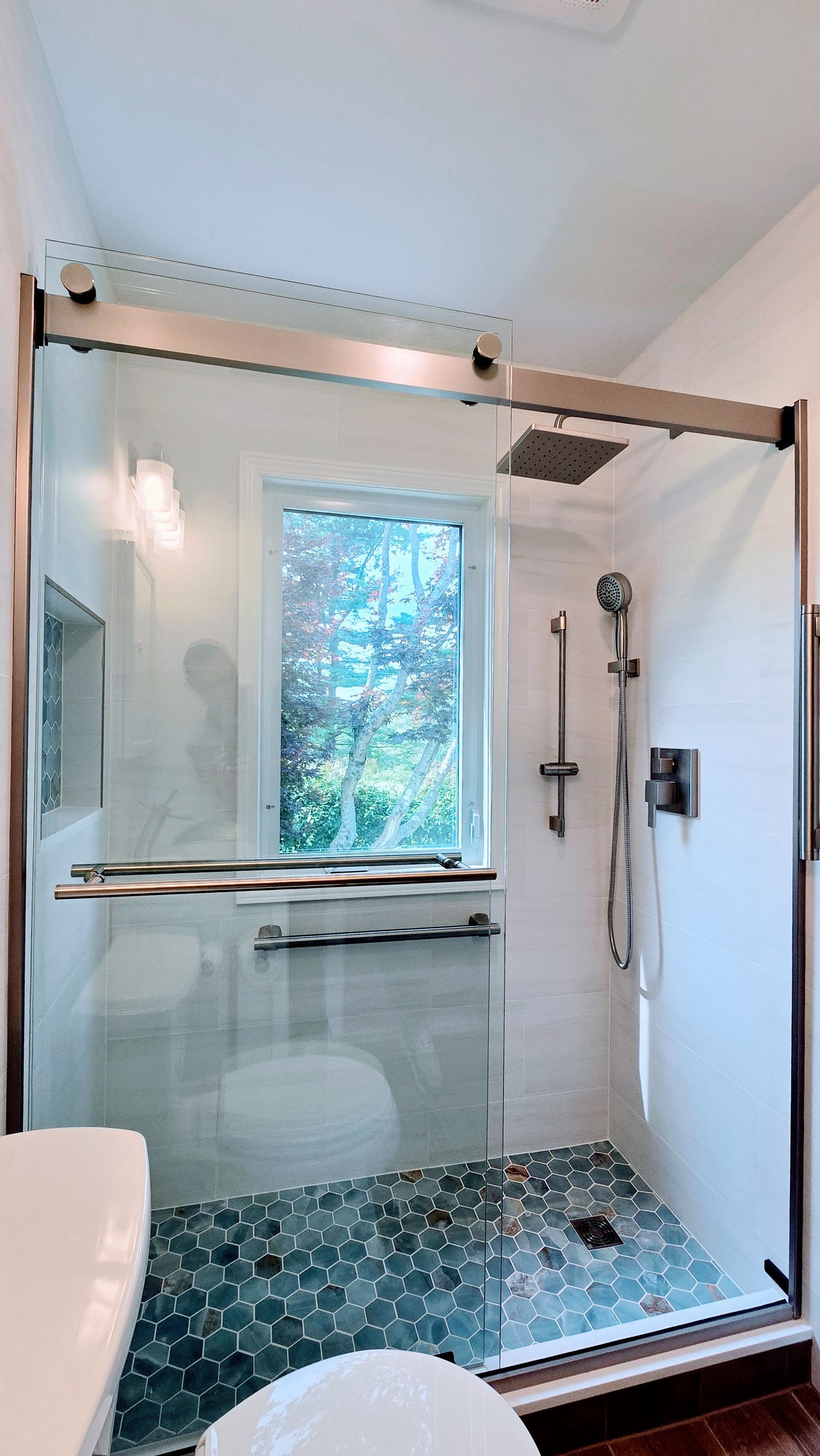 A bathroom with a walk in shower and a ceiling shower head.