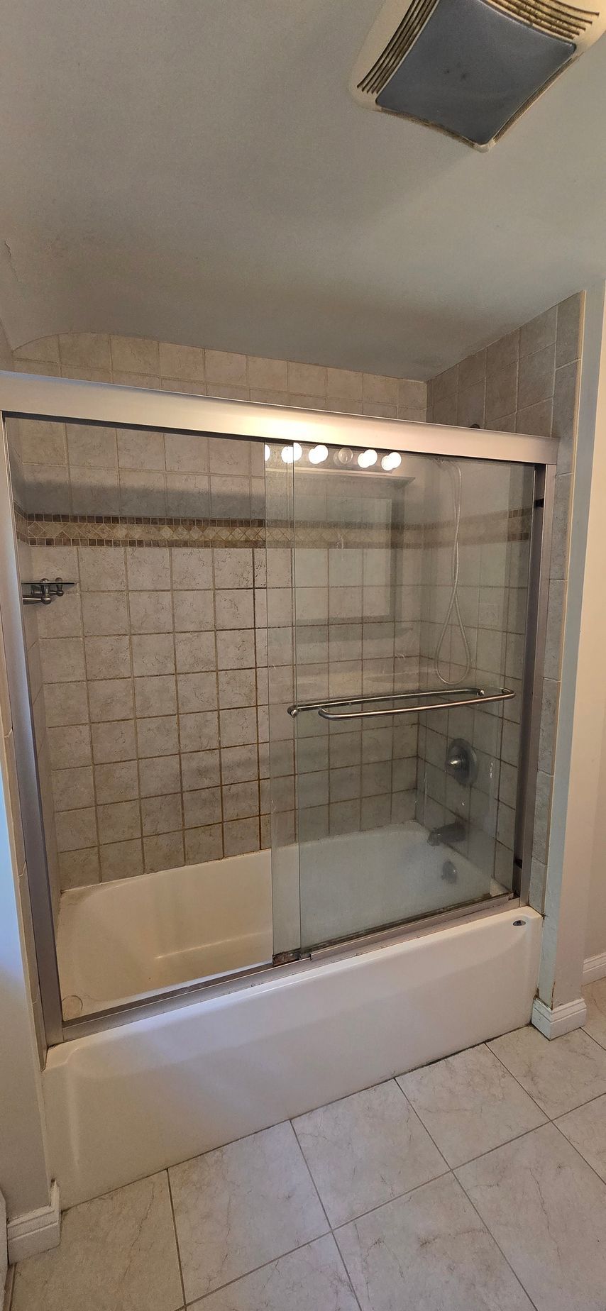 White bathroom vanity with frosted glass door panels and drawers, topped with a boat-shaped sink. Next to a white toilet.