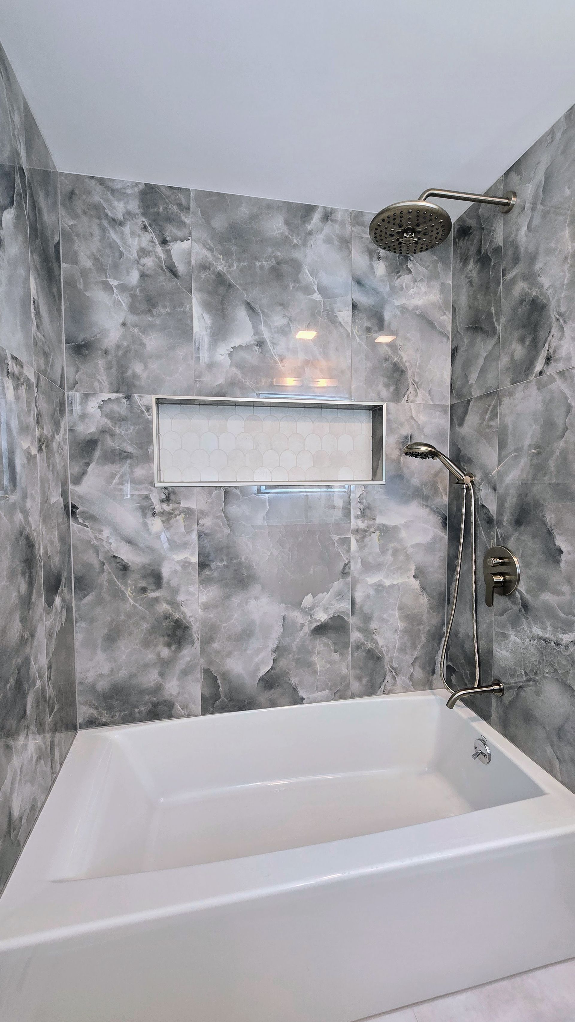 A bathroom with a bathtub and a shower head