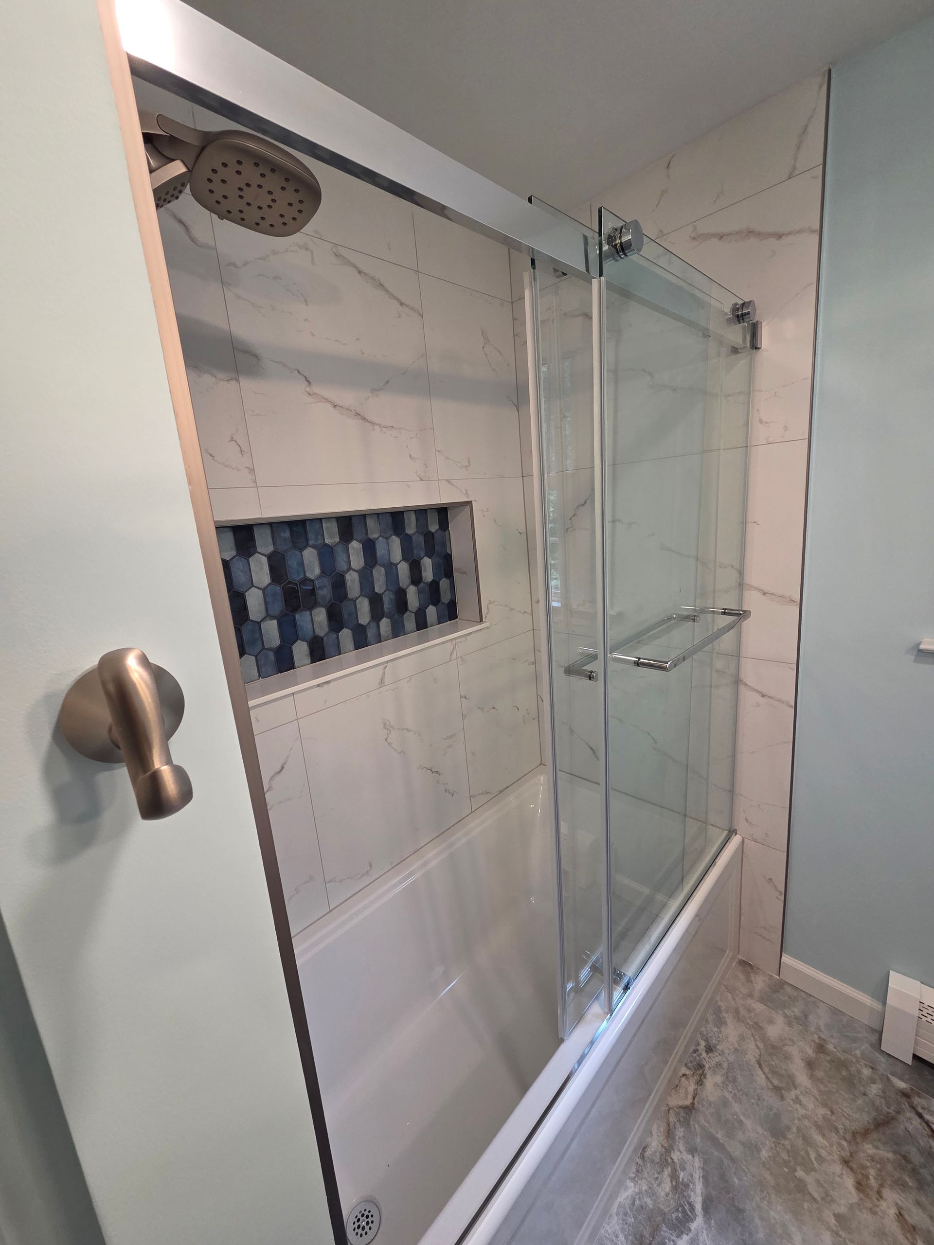 A bathroom with a bathtub and a shower head