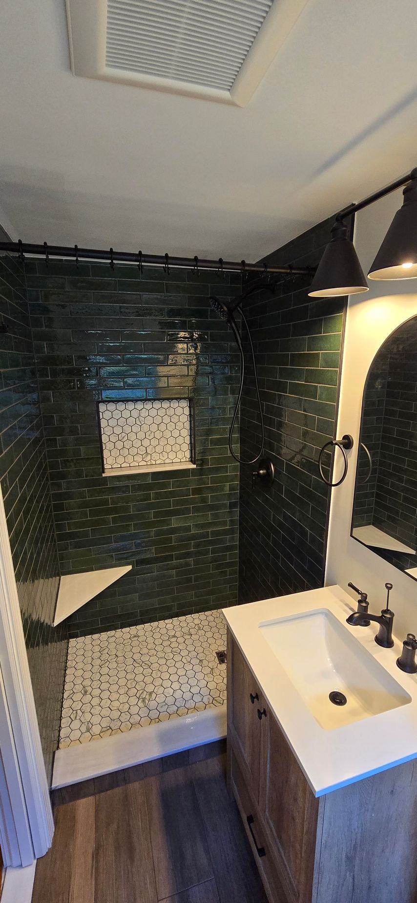 A bathroom with a walk in shower and a ceiling shower head.