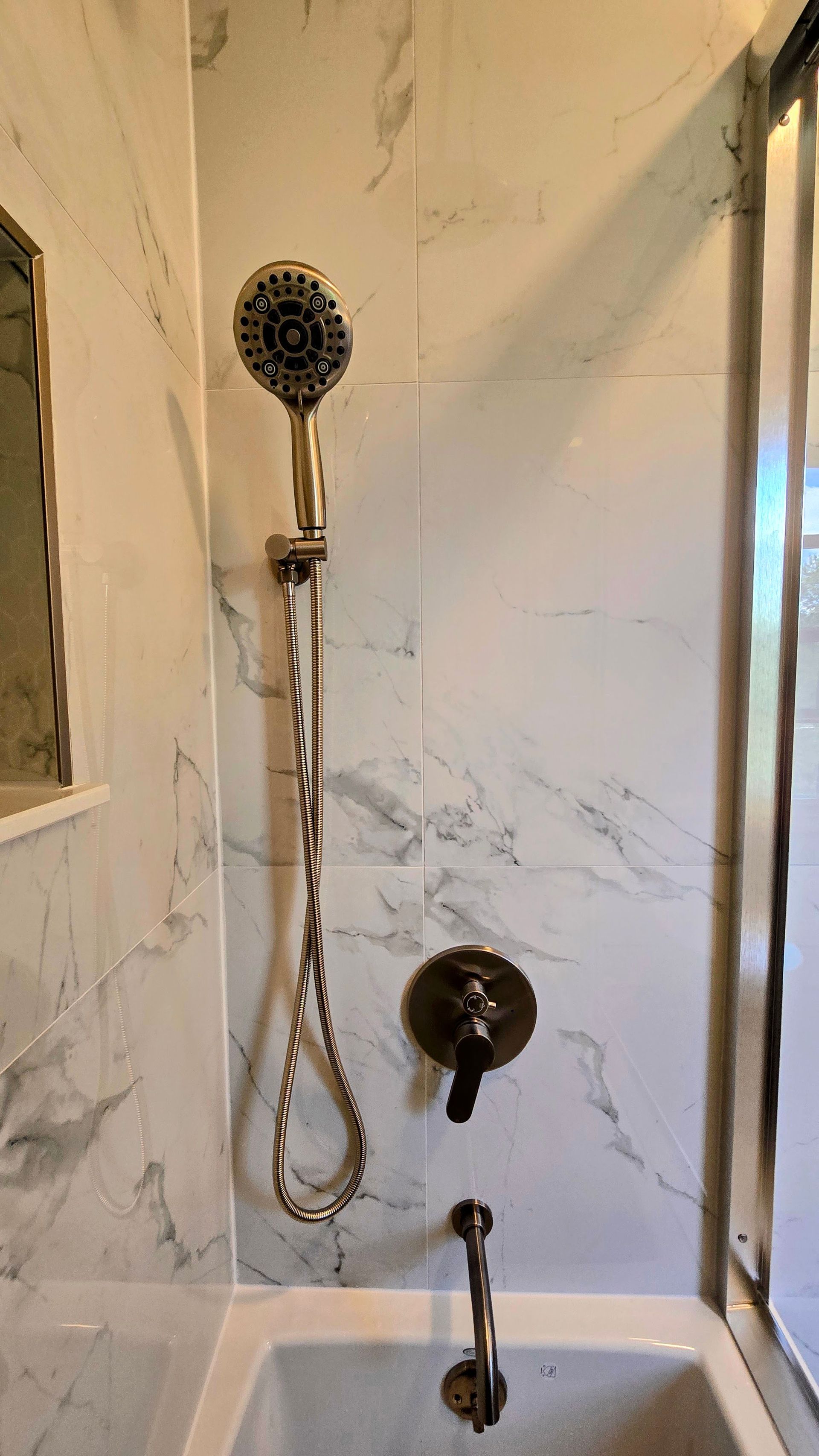 Hallway with doorway to Bristol bathroom. Pink tile floor, white door, beige walls.