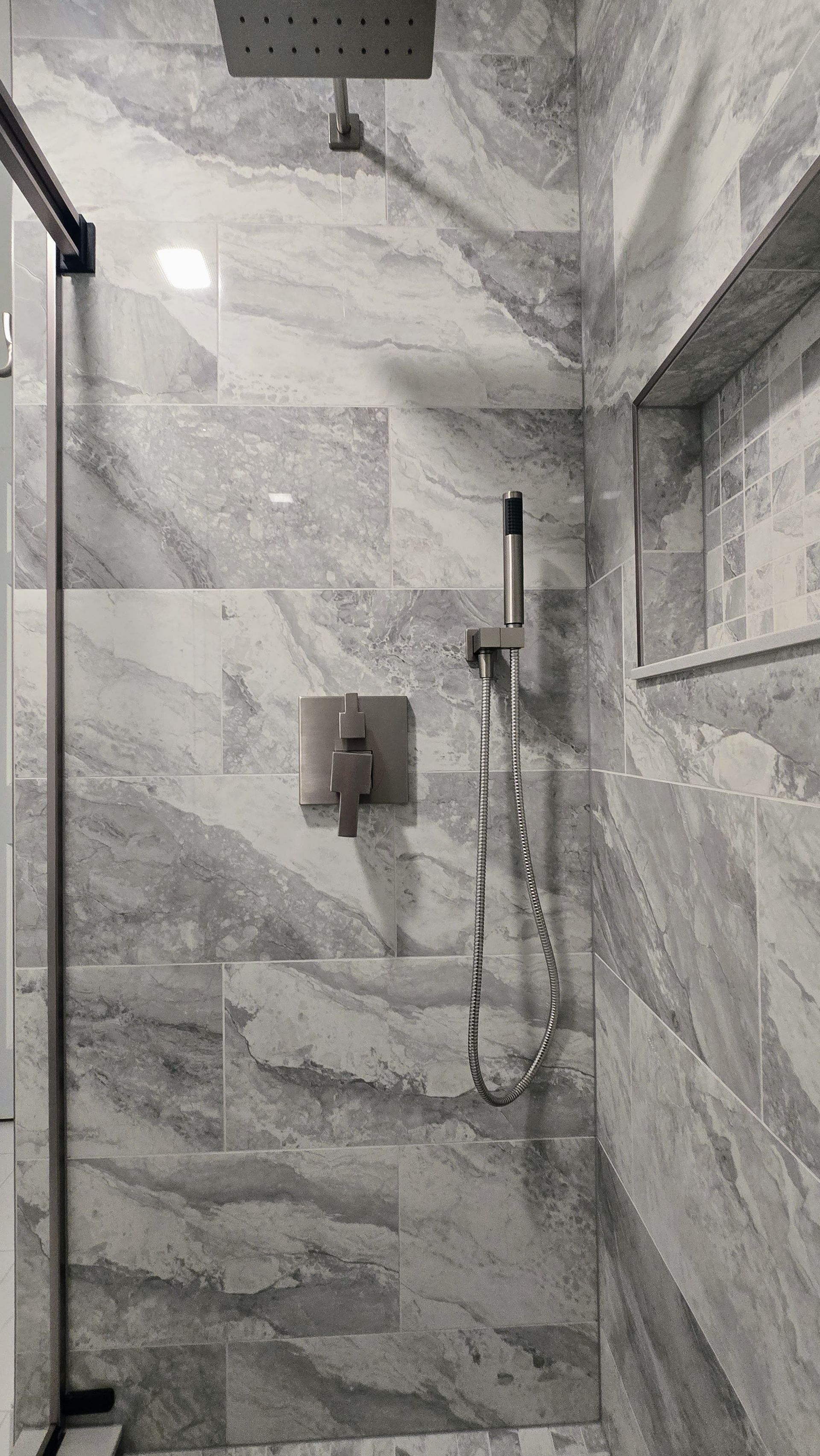 Bathroom with blue walls, a vanity with two sinks, and two globe pendant lights.