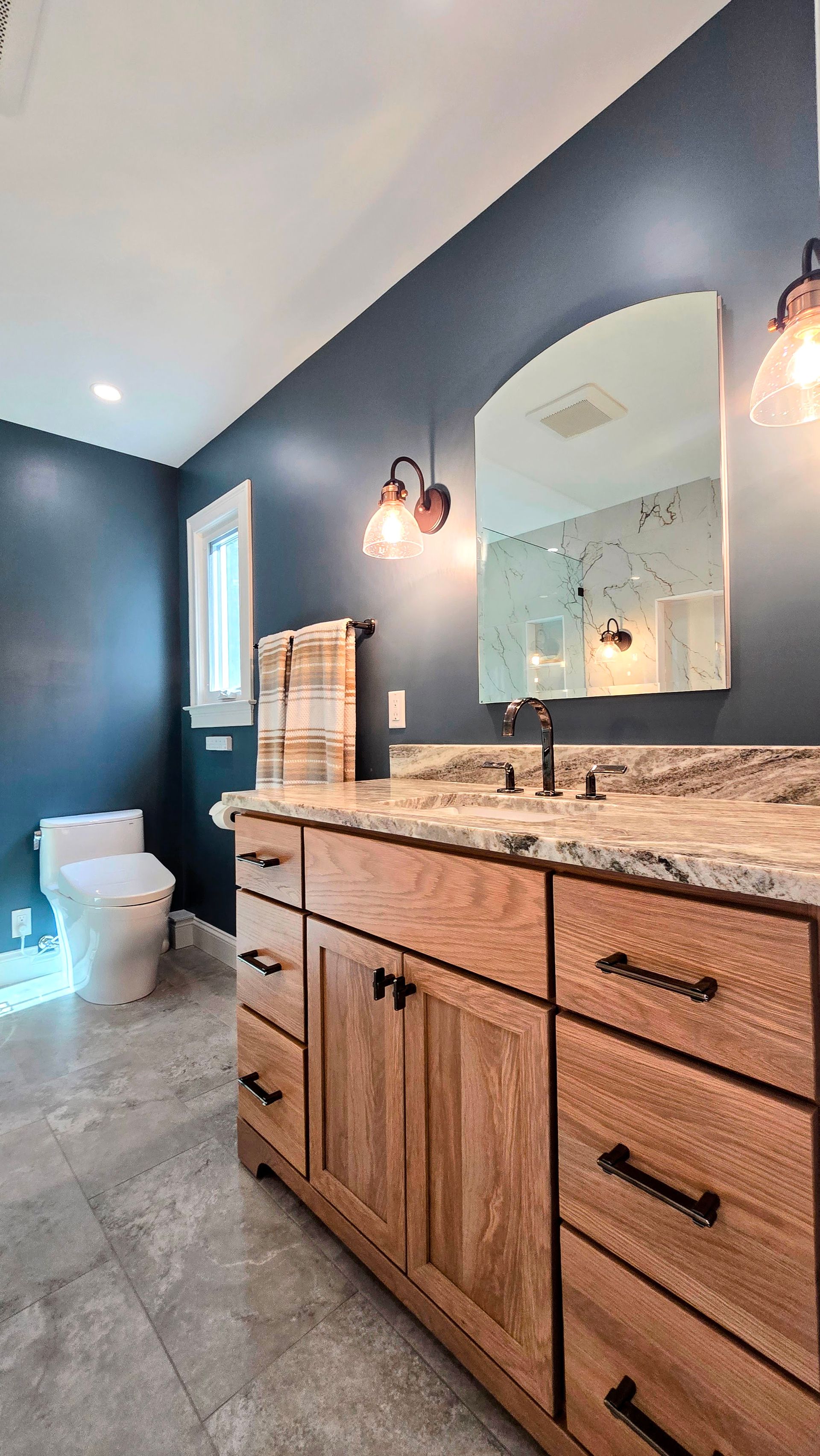 Bathroom remodel near Avon, CT with a freestanding tub, shower, and vanity; gray tile, teal accent wall.