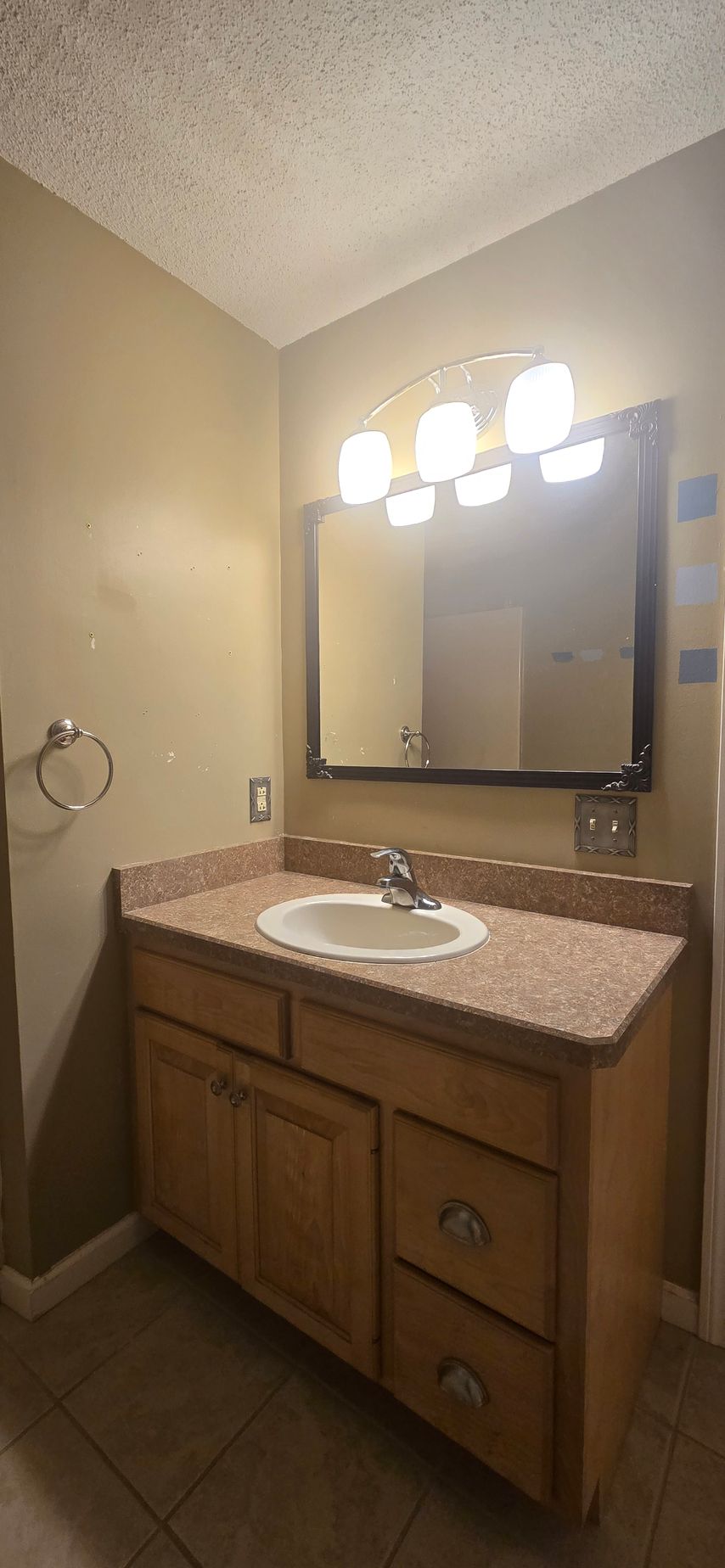 Marble-tiled walk-in shower remodel in Wolcott, CT with gold fixtures, pebble floor, and recessed shelf with toiletries.
