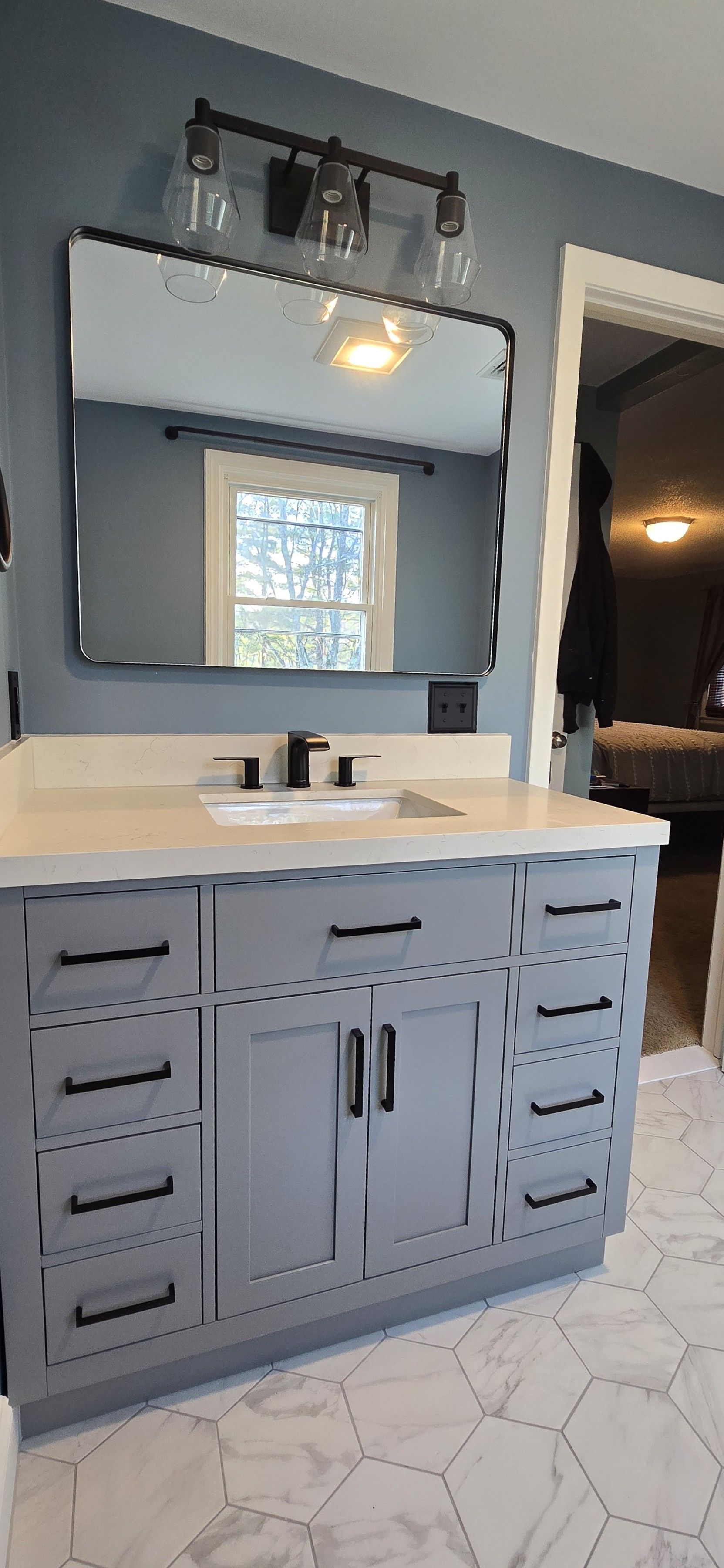 Middletown bathroom vanity with a gray cabinet, white countertop, black fixture, and a large mirror.