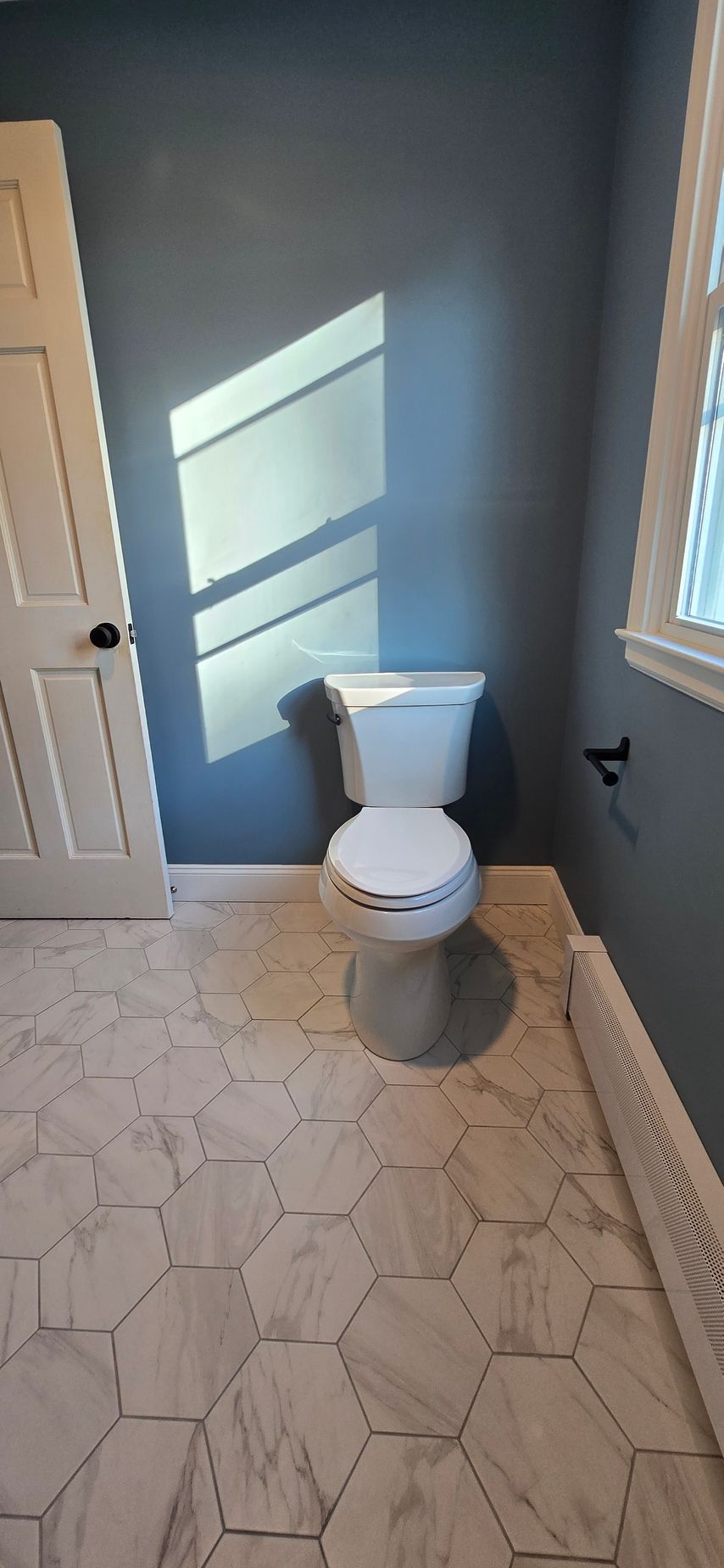 Bristol bathroom vanity with black fixtures, lit mirror, and neutral walls.