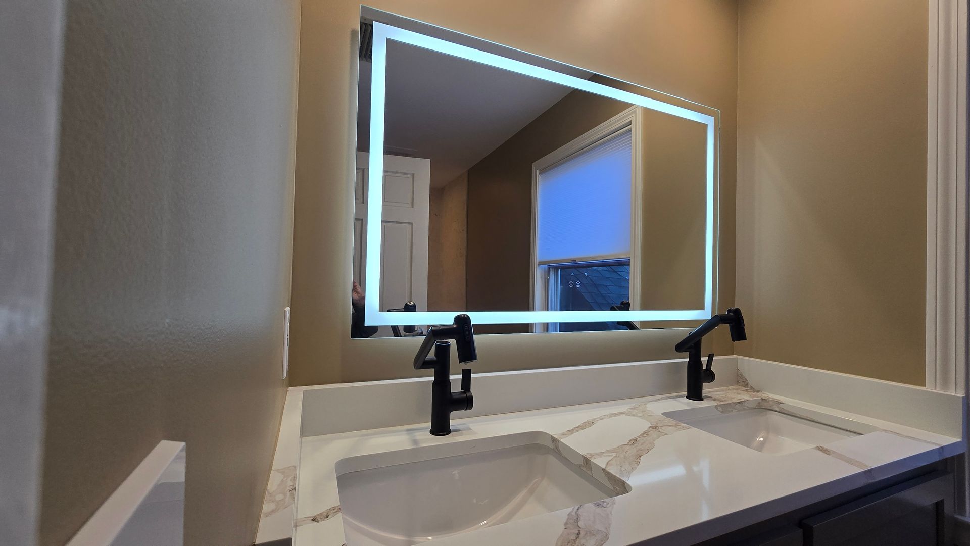 Marble-tiled walk-in shower remodel in Wolcott, CT with gold fixtures, pebble floor, and recessed shelf with toiletries.