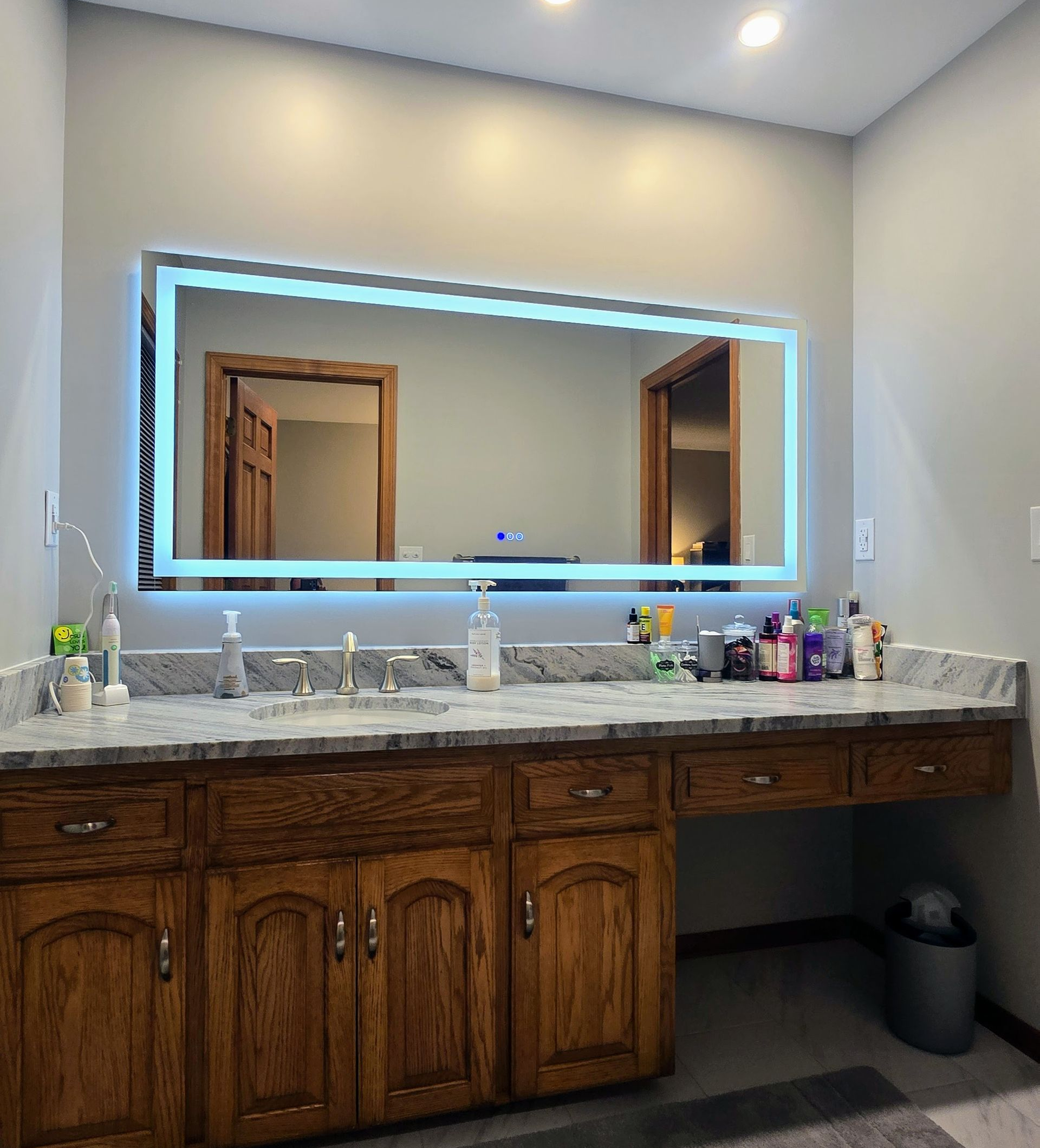 Plainville bathroom with gray stone-like tiles, two built-in shelves, and a dark metal showerhead.