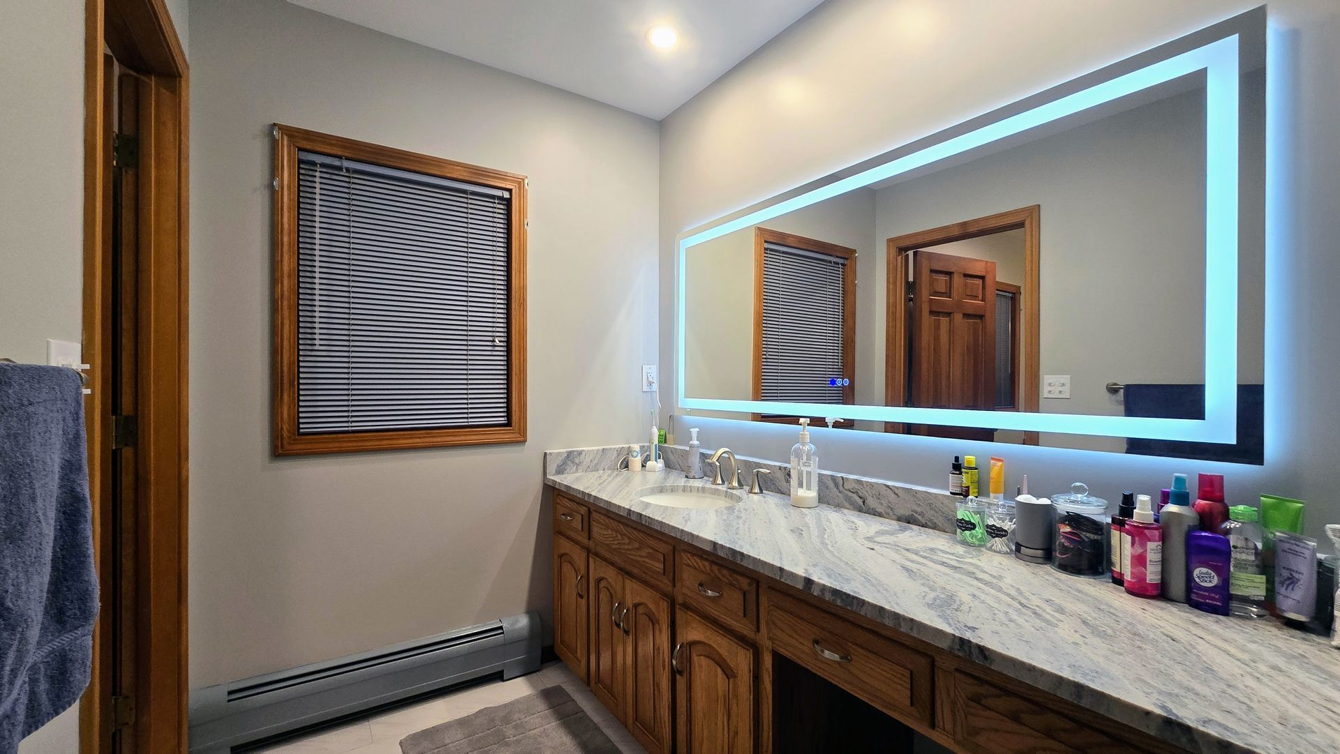 Bristol bathroom vanity with black fixtures, lit mirror, and neutral walls.