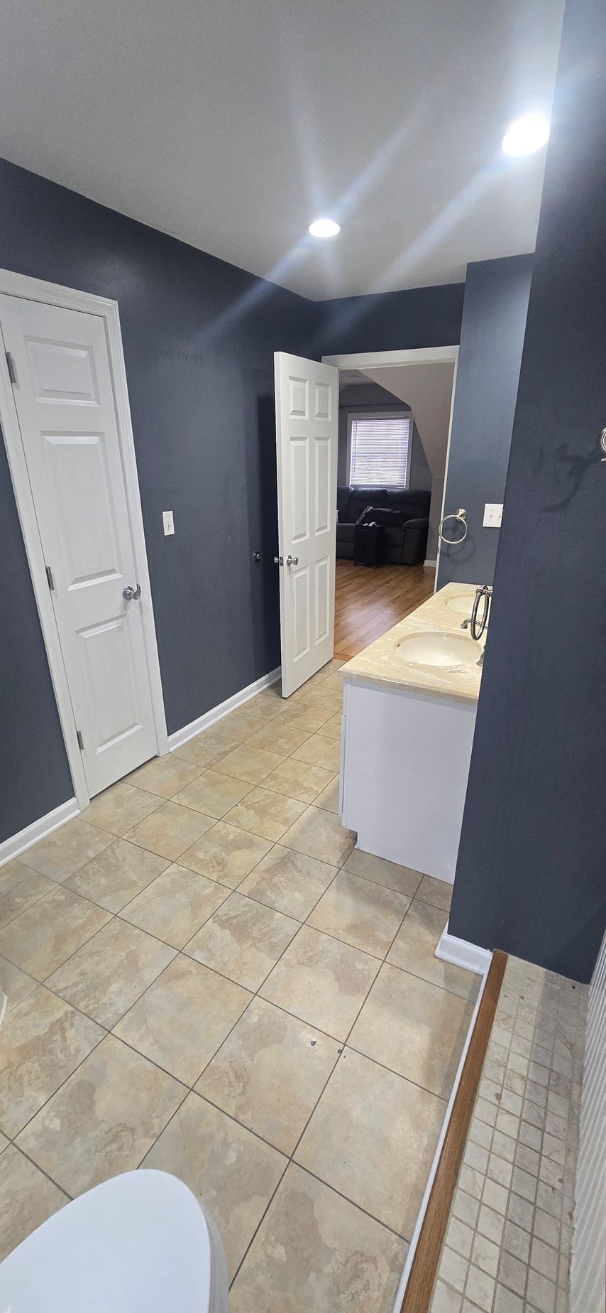 Bristol bathroom with large, illuminated mirror over a white countertop, black faucets, and a sink.