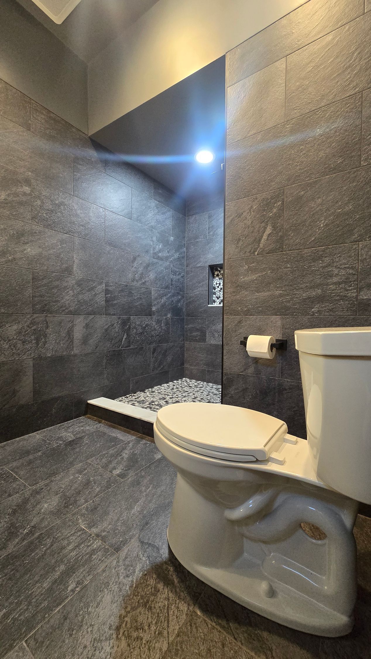 Bristol bathroom with large, illuminated mirror over a white countertop, black faucets, and a sink.