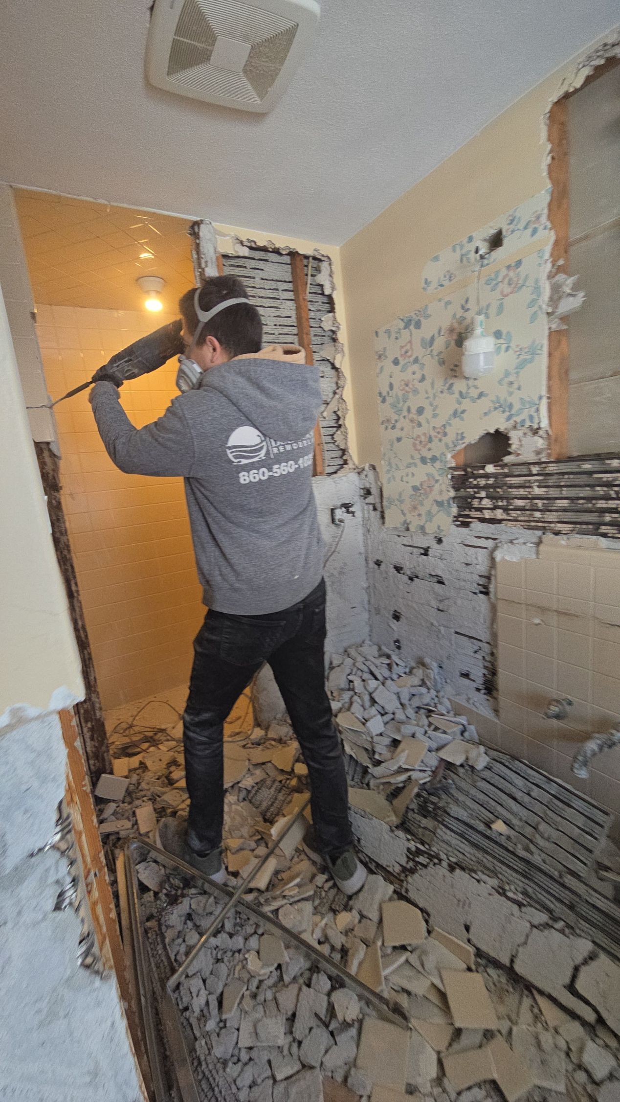 Construction of a Newington CT wall frame with exposed lathe and plaster. A measuring tape is stretched across the frame. Done by First Choice.