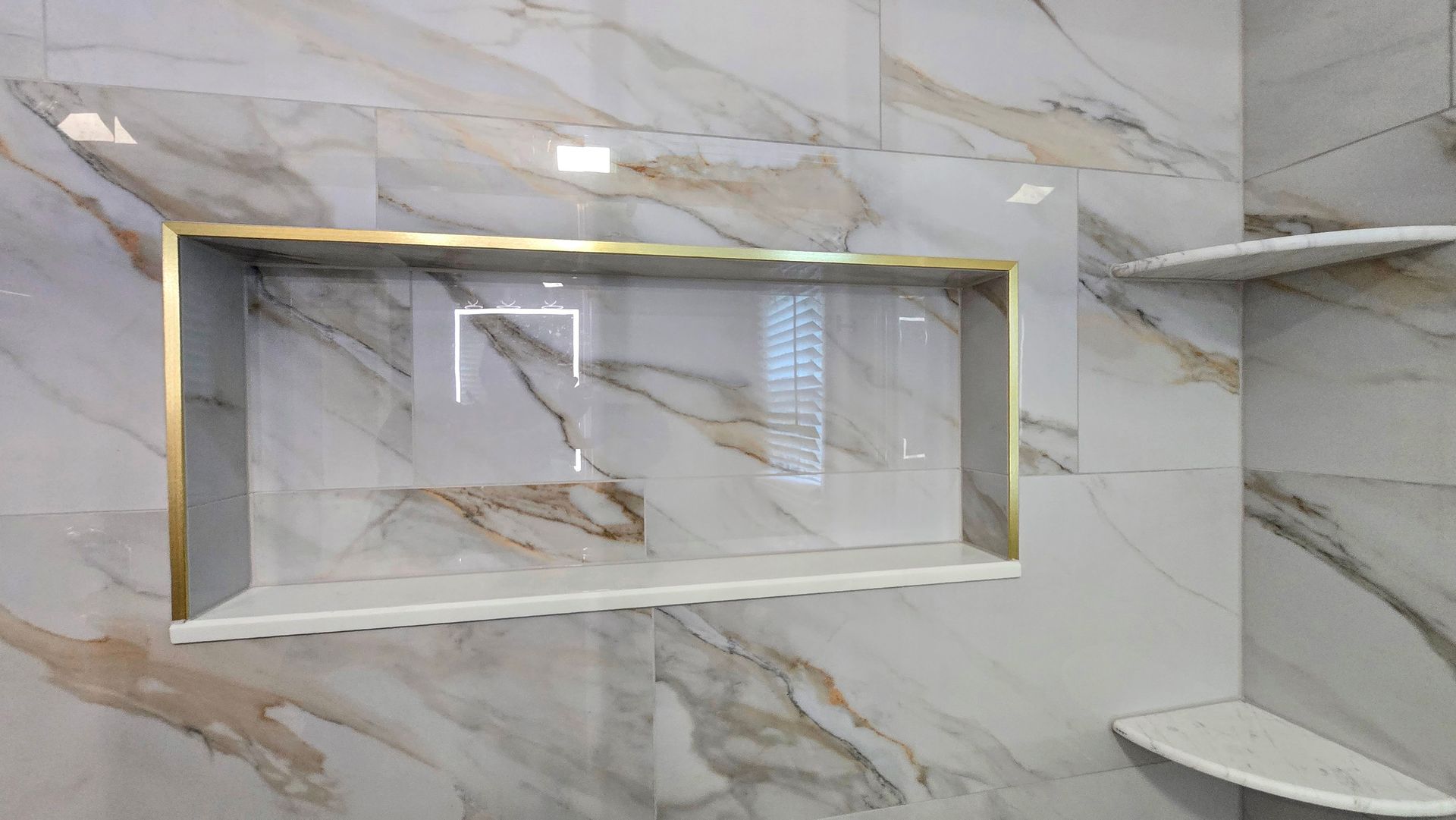 A modern bathroom in Simsbury, CT with a glass-enclosed shower, a dark wood vanity with a backlit mirror, and blue floor accent lighting.
