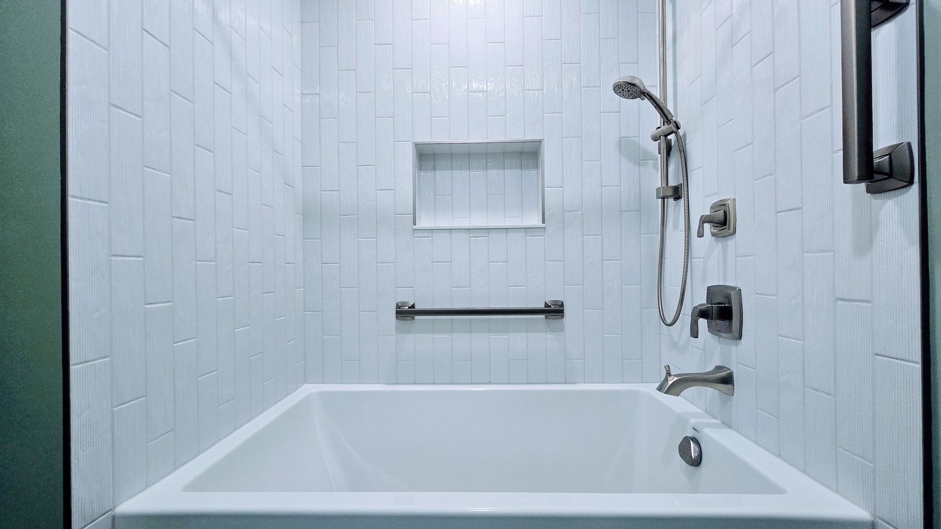 A white bathtub with chrome faucets and a white towel on the side