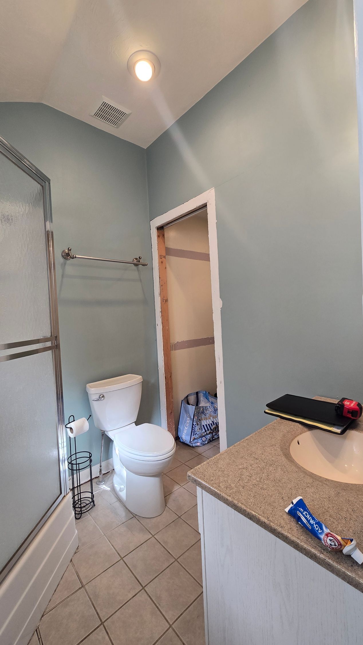 Bristol Bathroom with double sinks, lit mirror, wooden cabinets, and window.