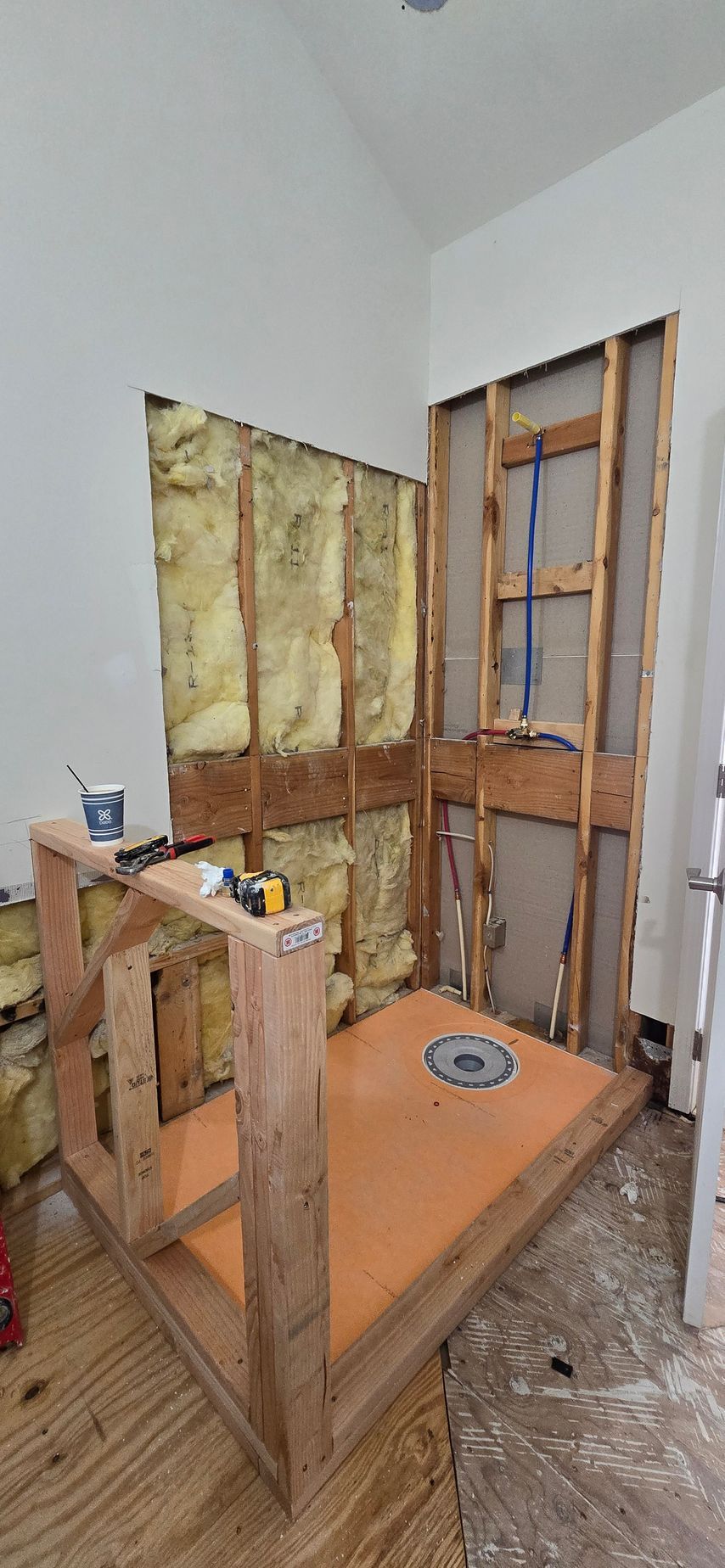 Shower remodel in progress; framing, orange pan, exposed walls.