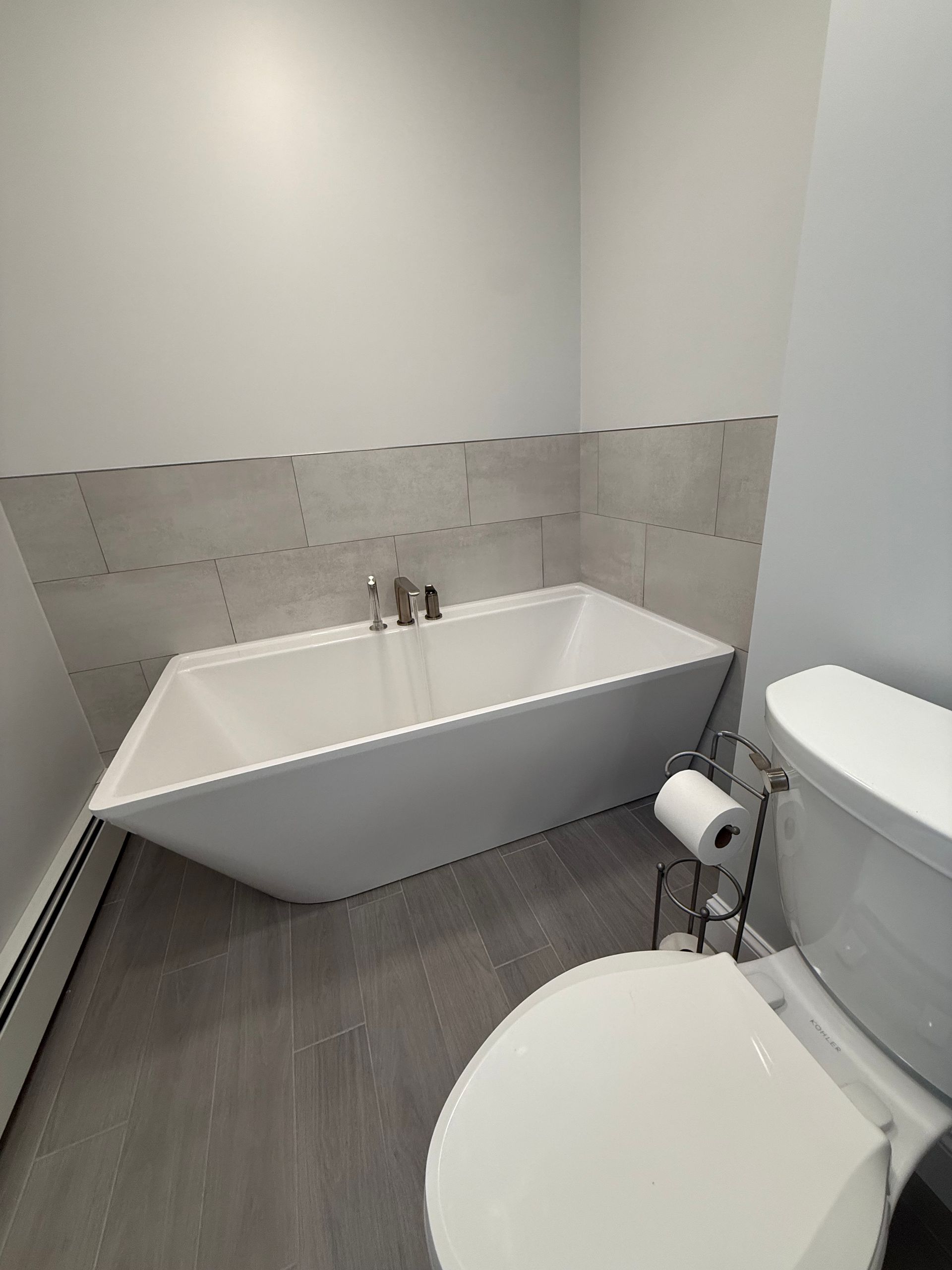 A bathroom with a bathtub and toilet.