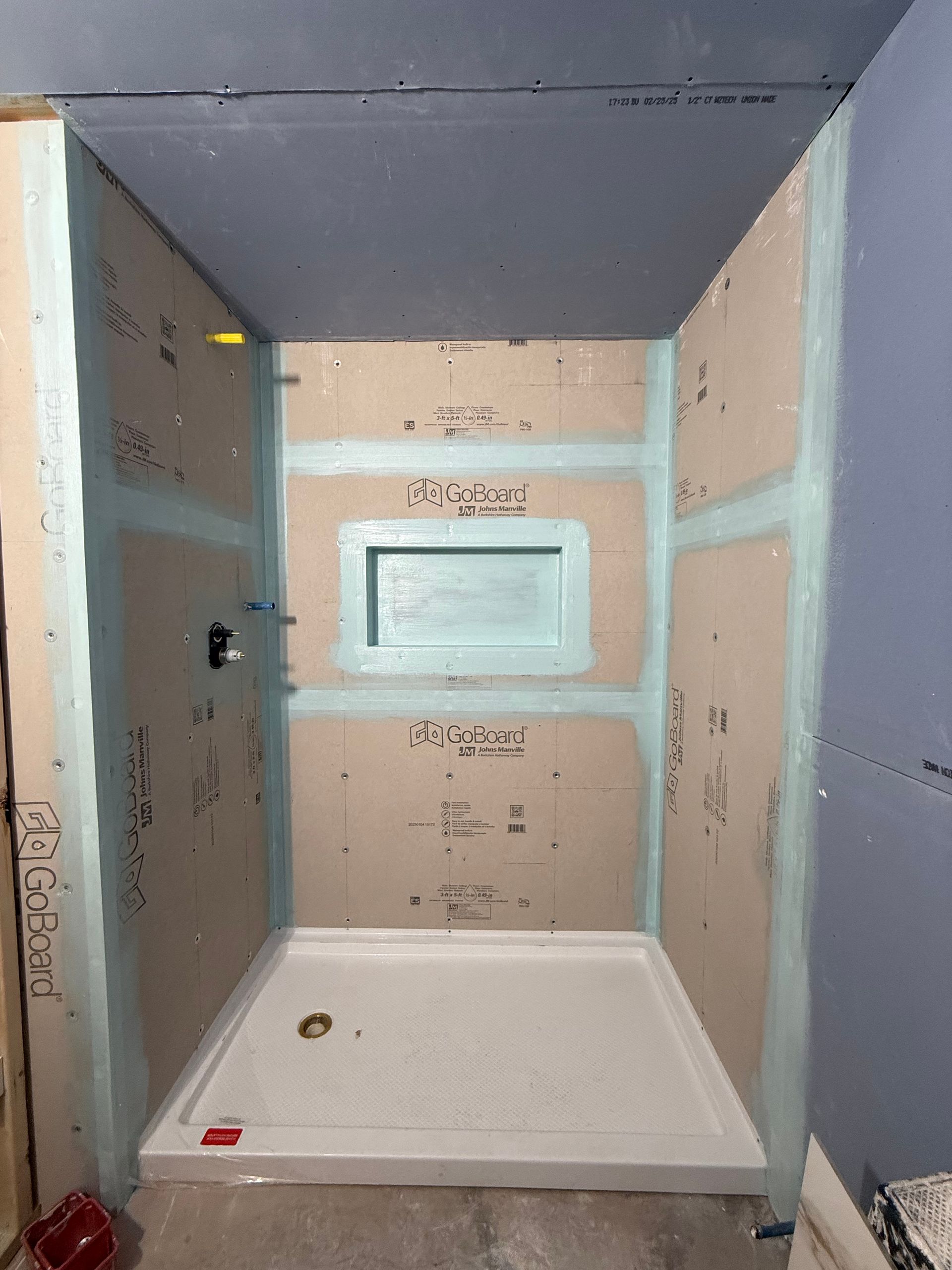 A shower stall is being built in a bathroom.