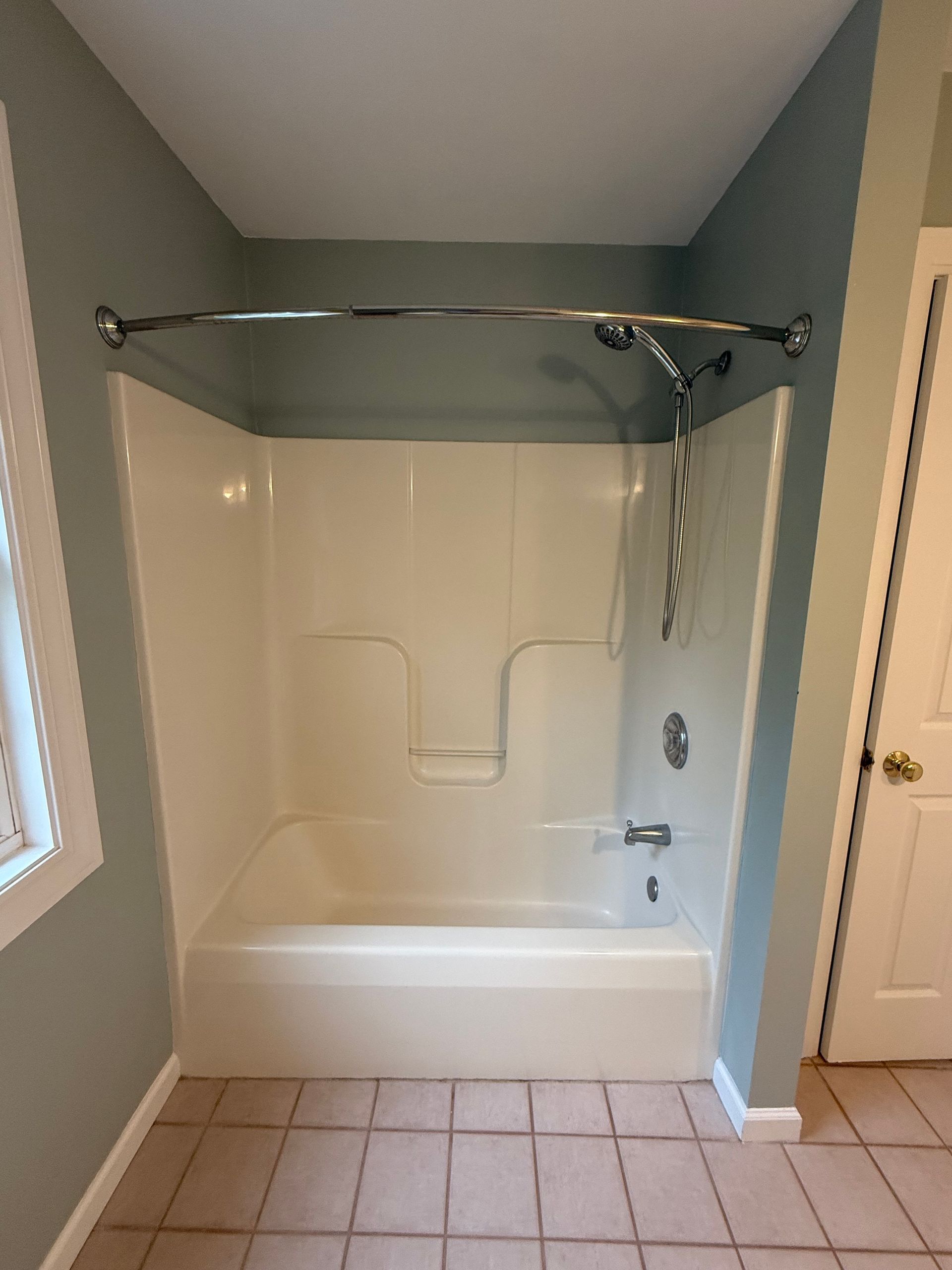 A bathroom with a bathtub , sink , and shower.