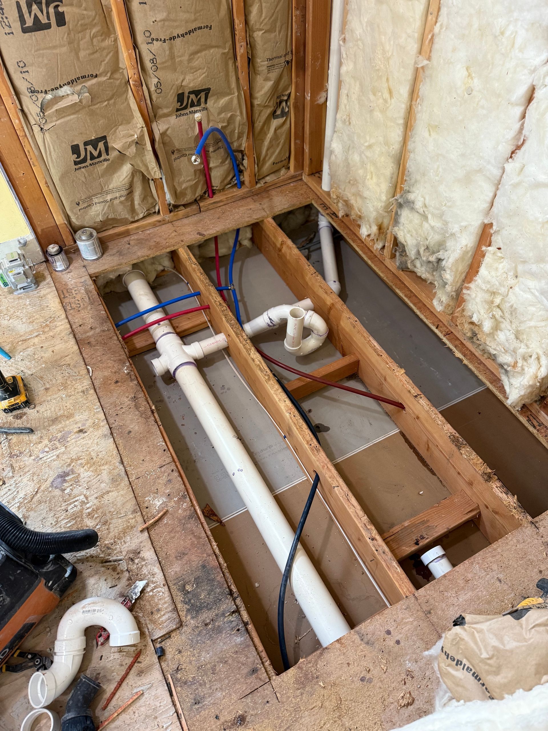 A bathroom with a toilet , sink , mirror and shower.