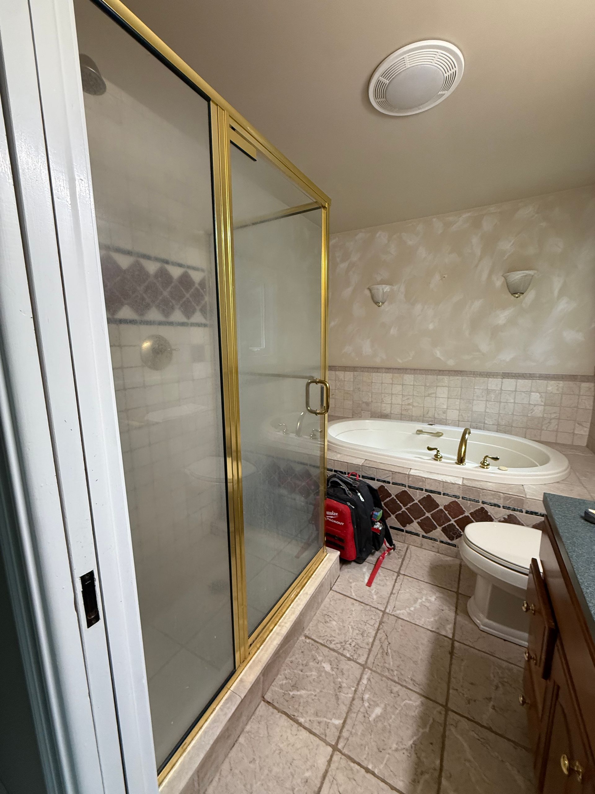 Avon Bathroom with gold-framed shower, bathtub, toilet, and vanity;